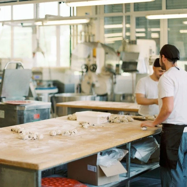 Menschen in einer Bäckerei, die Teig kneten
