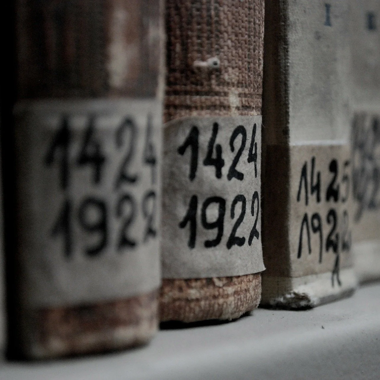 Bündel mit alten Papierstapeln, darauf handgeschriebene Jahreszahlen wie 1924, 1922, 1925.