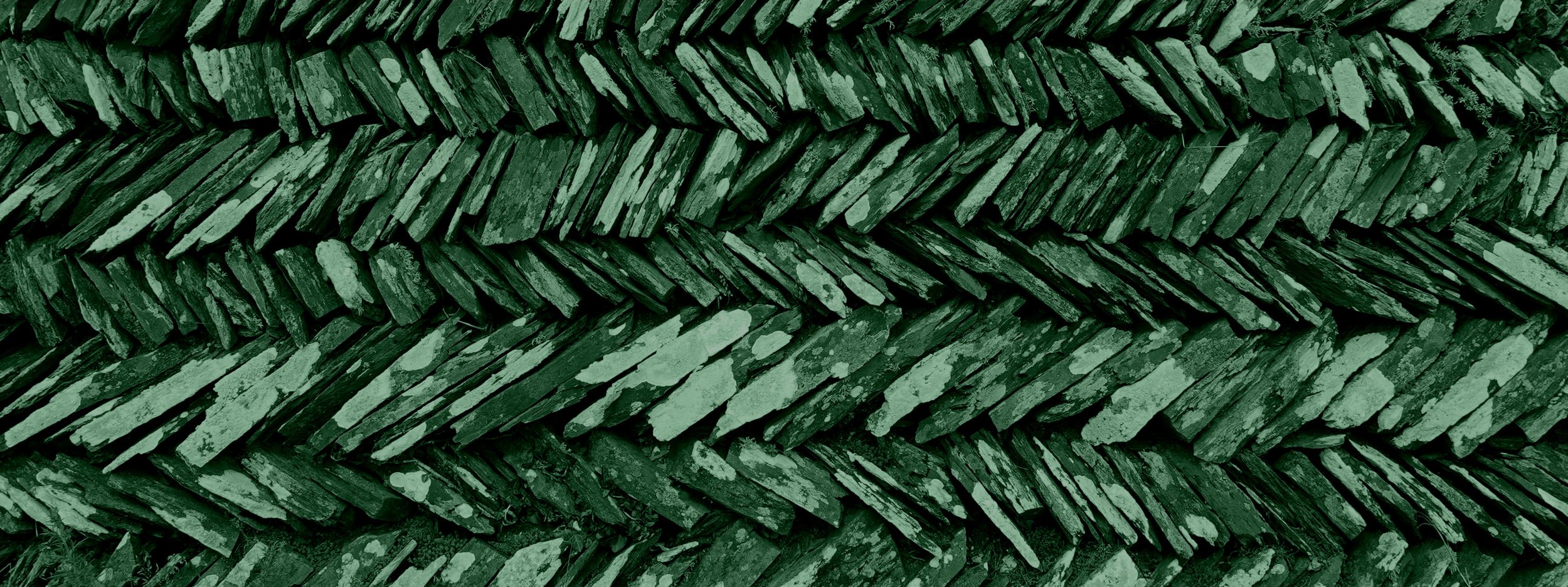 Close-up of a stack of green-painted wooden planks arranged in a layered pattern.