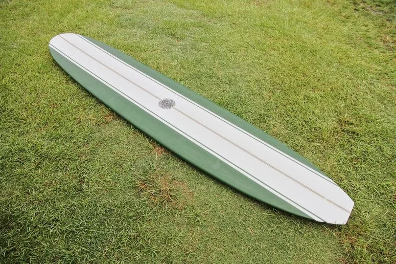 A surfboard lying on green grass outdoors.