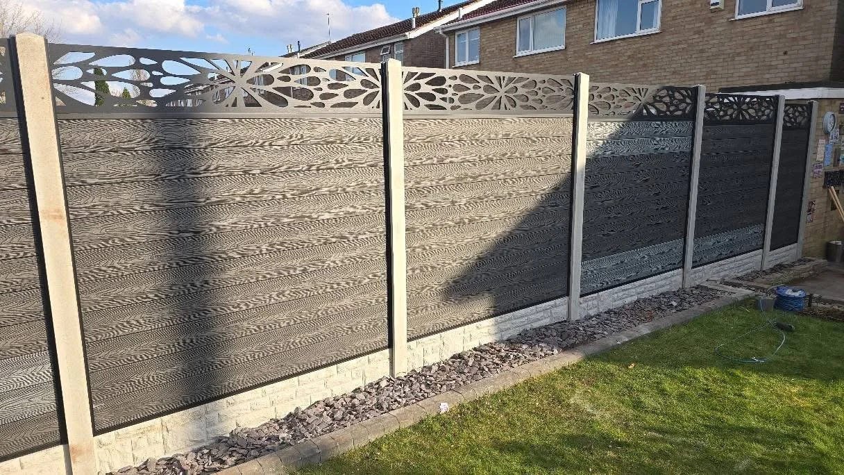 New decorative fence panels in a backyard, with patterned tops and horizontal wooden slats.