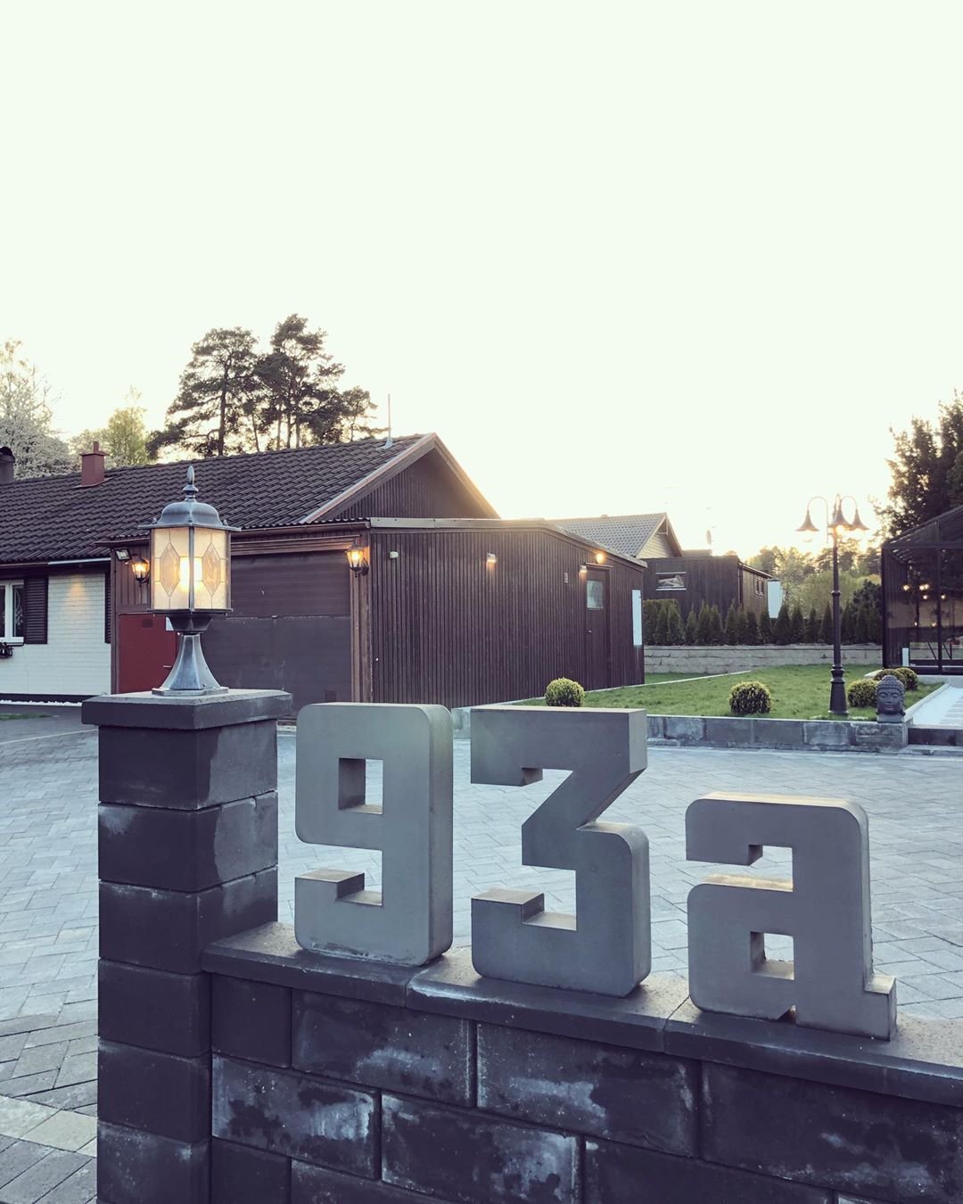 Talonumero 93a tummanharmaa teräksessä tummalla puupaneelijulkisivulla