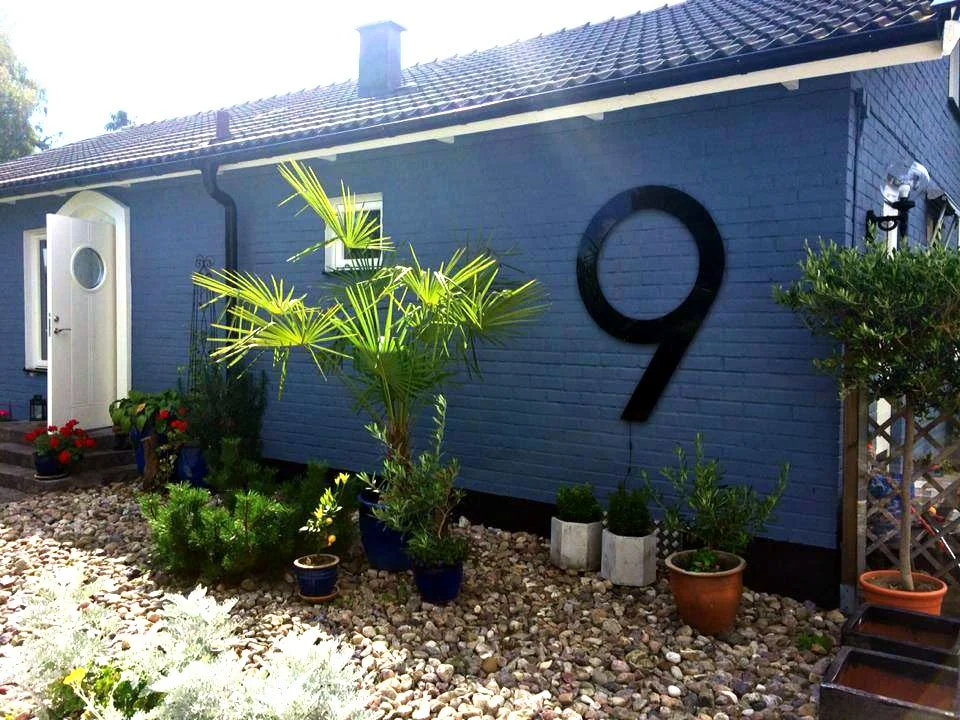 Suuri musta akryylinen talonumero 9 ulkoseinässä