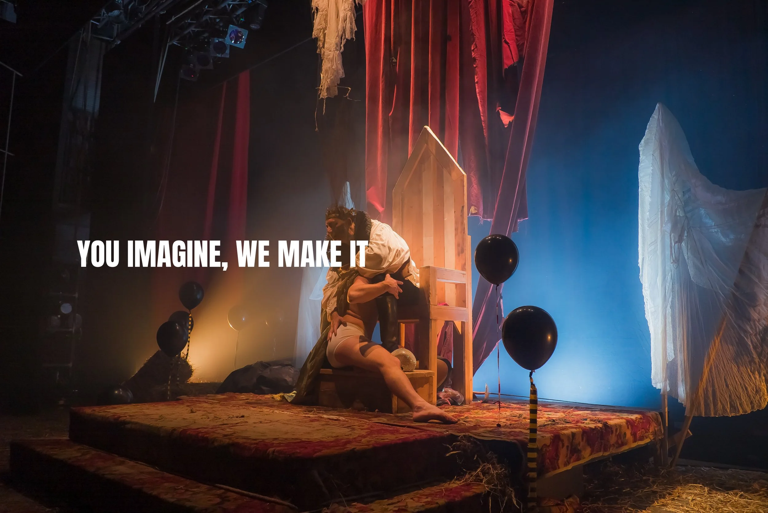 Stage setup with a person leaning against a wooden structure, surrounded by black balloons, fabric drapes, and colorful lighting. Text overlay saying, 'YOU IMAGINE, WE MAKE IT.'