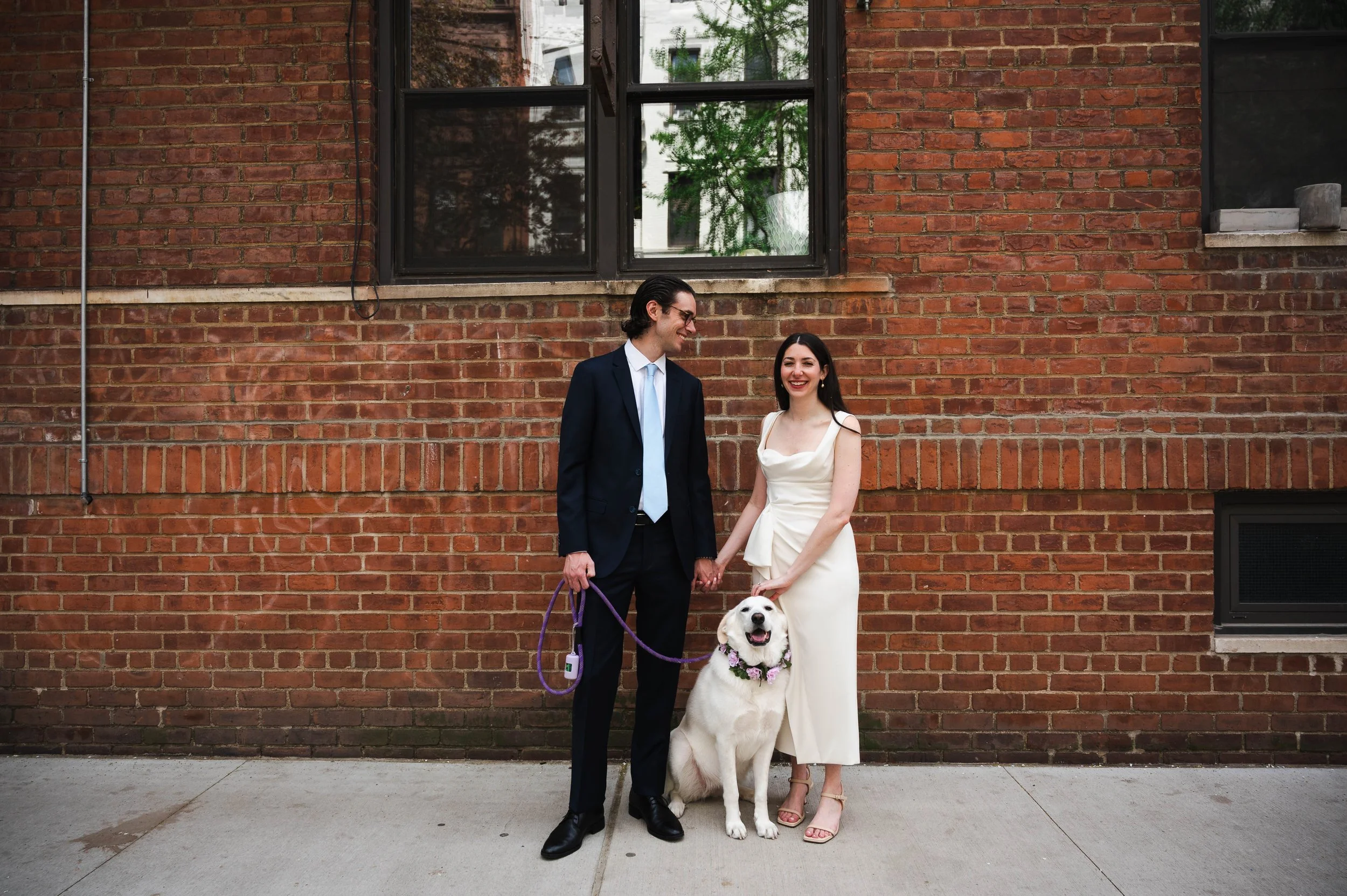 Couple posing with their dog on the Upper West Side before their Manhattan City Hall wedding ceremony