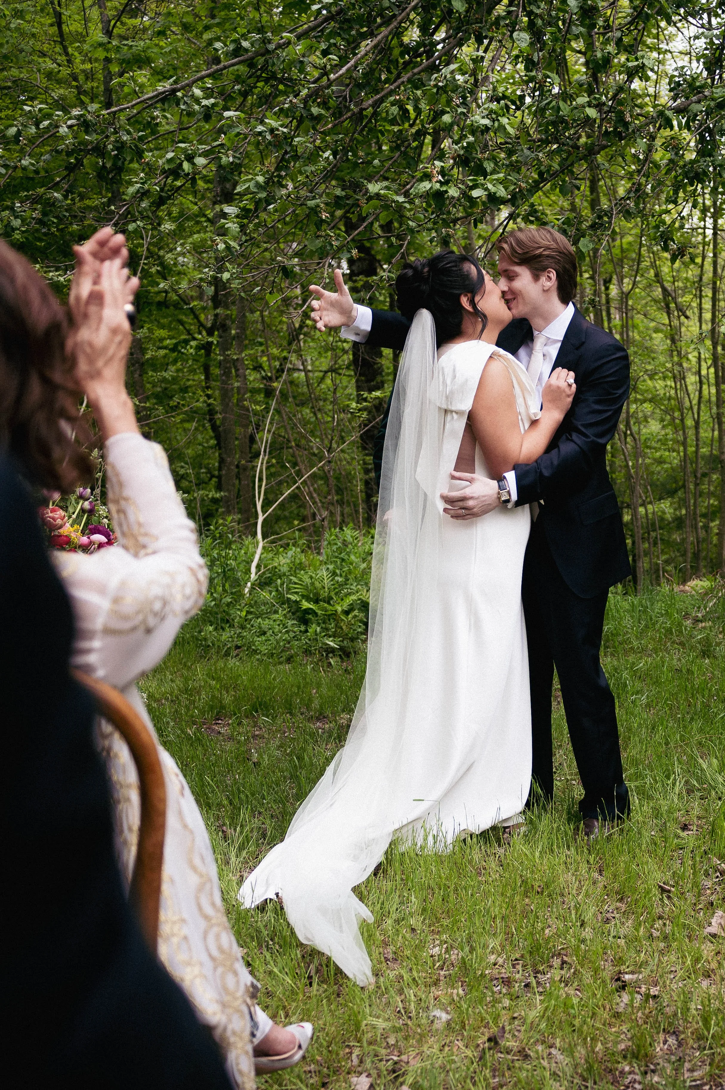 Bride and groom sharing a kiss during their outdoor wedding ceremony in upstate New York