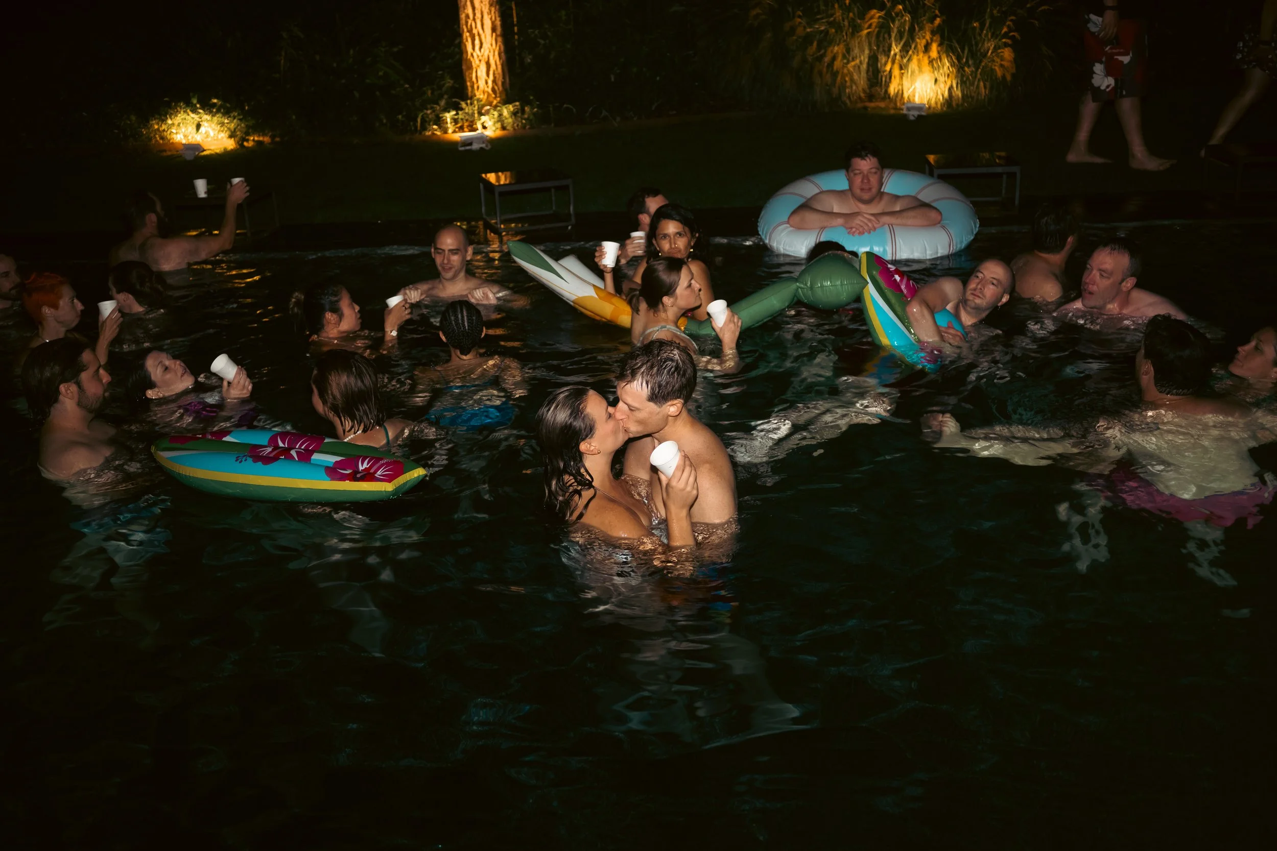  Bride and groom sharing a romantic kiss in the illuminated pool during their pre-wedding party in Bolzano, Italy. 