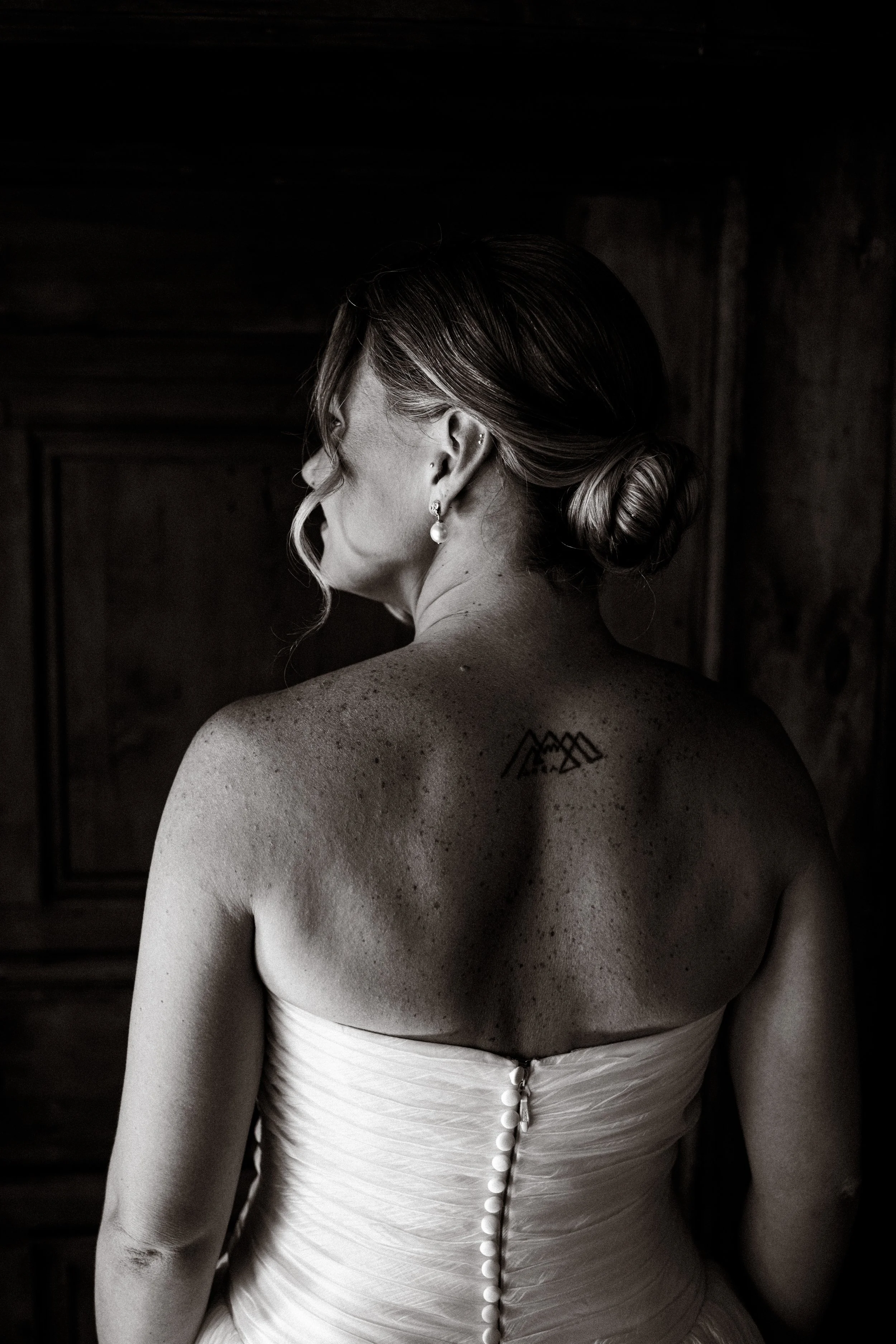  Dramatic, fine-art bridal portrait framed by dark antique wooden doors in the interior of Castel Hörtenberg. 