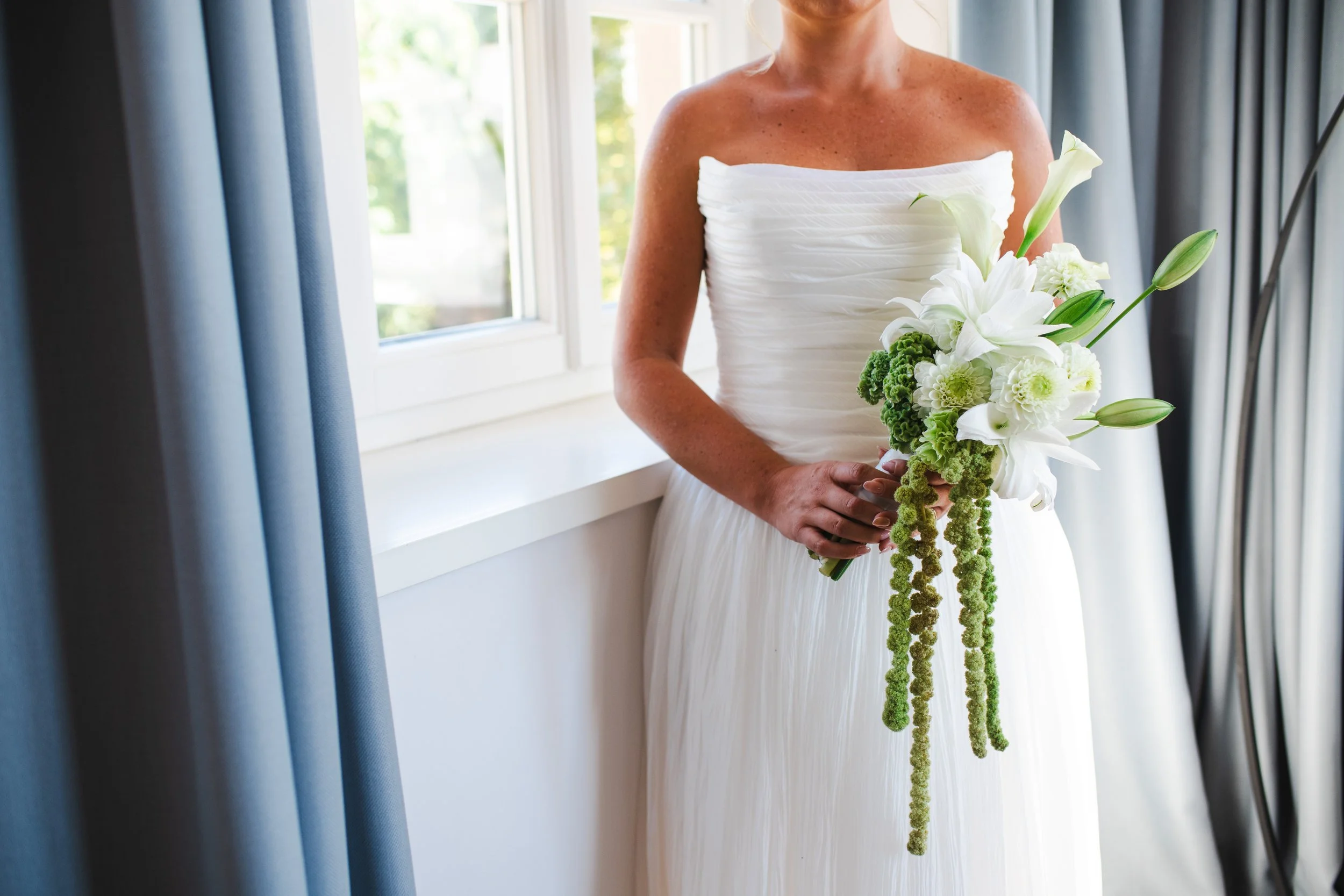  Close-up detail shot of the bride's custom floral wedding bouquet featuring elegant luxury blooms. 