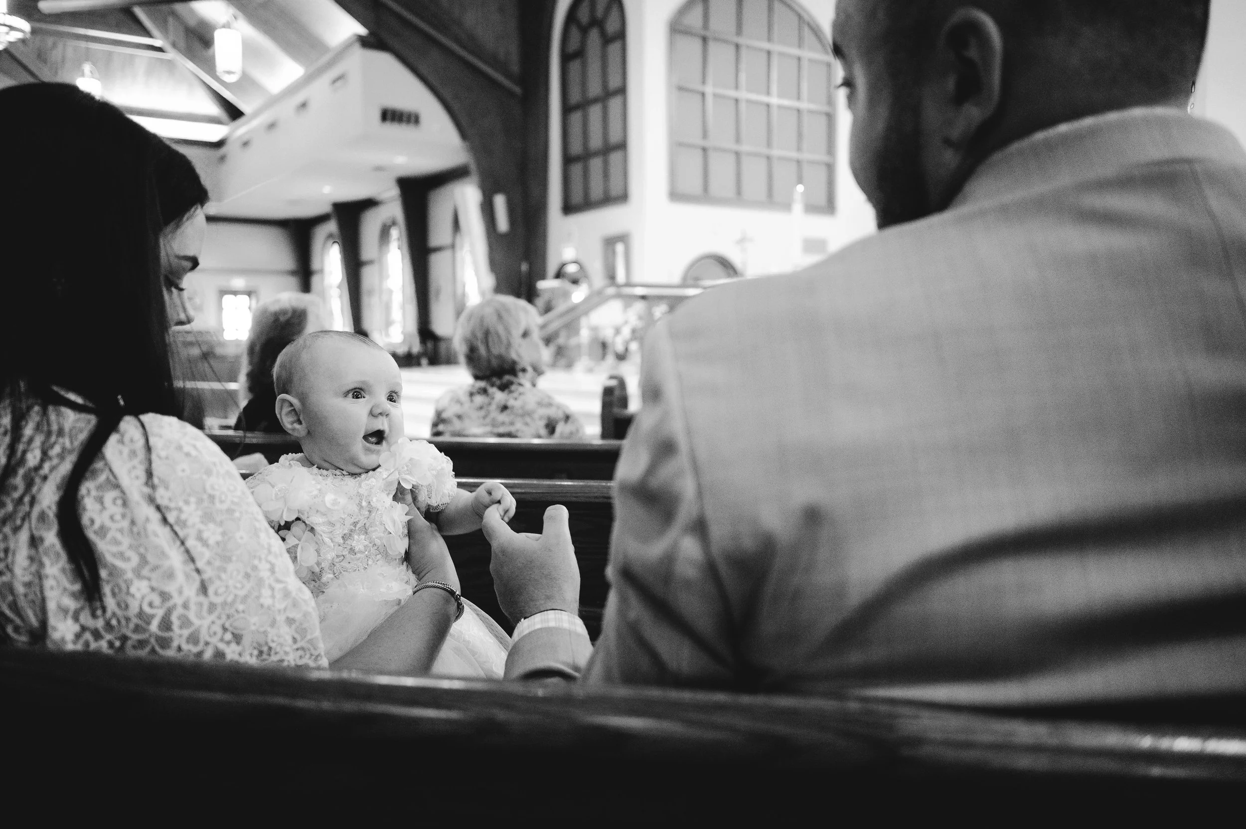  Family seated in a pew during a baptism ceremony photographed in South Carolina