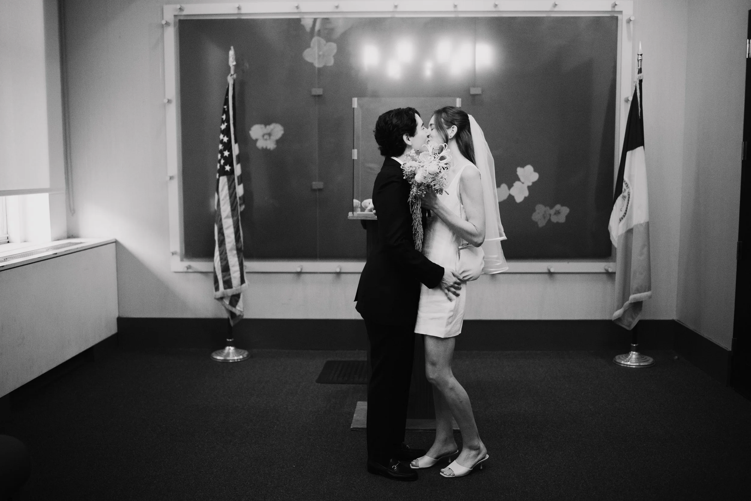 Queer couple sharing a kiss immediately after their Manhattan courthouse wedding ceremony