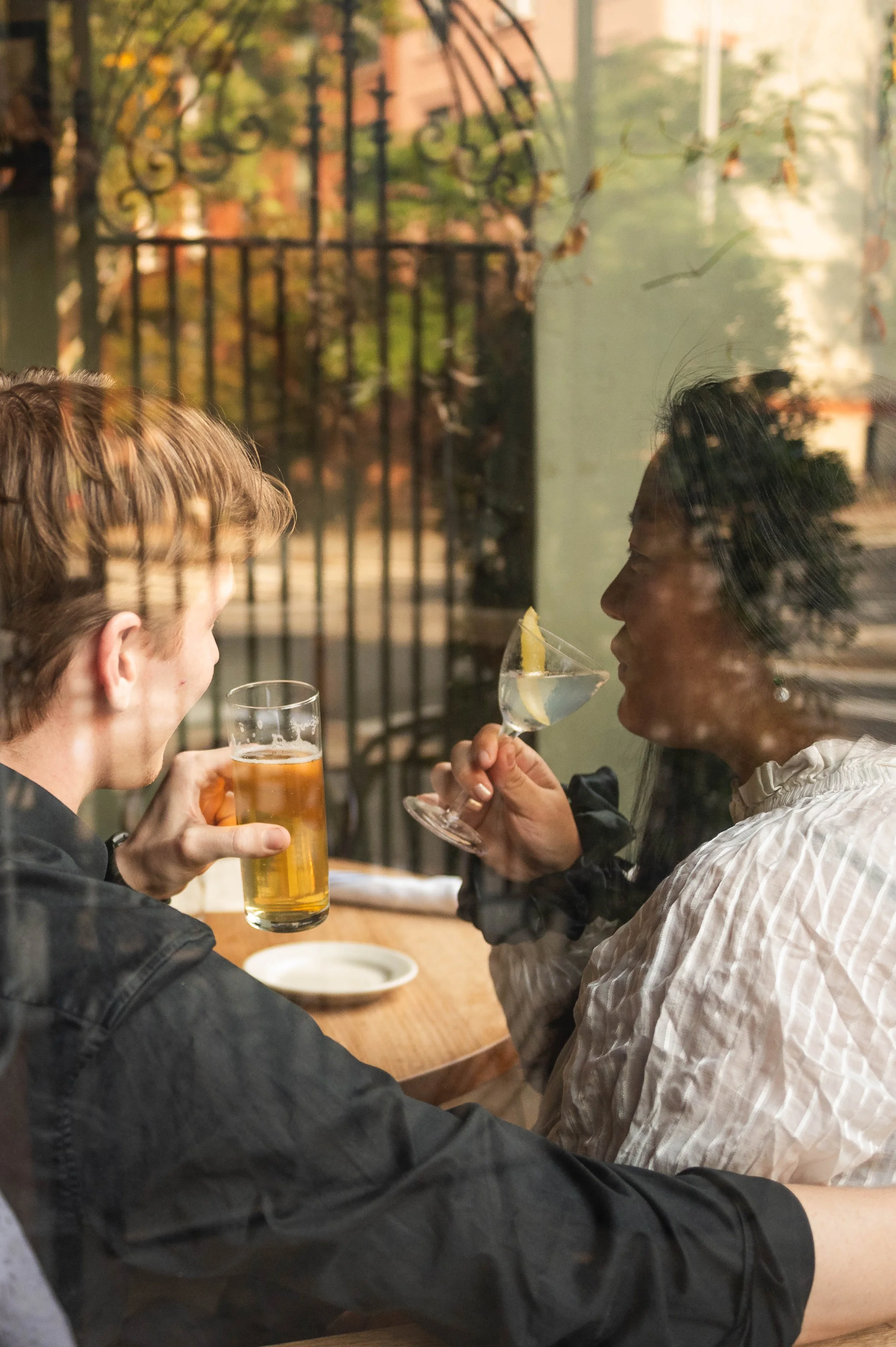 Artistic portrait of a couple sitting inside a Brooklyn restaurant during their engagement session