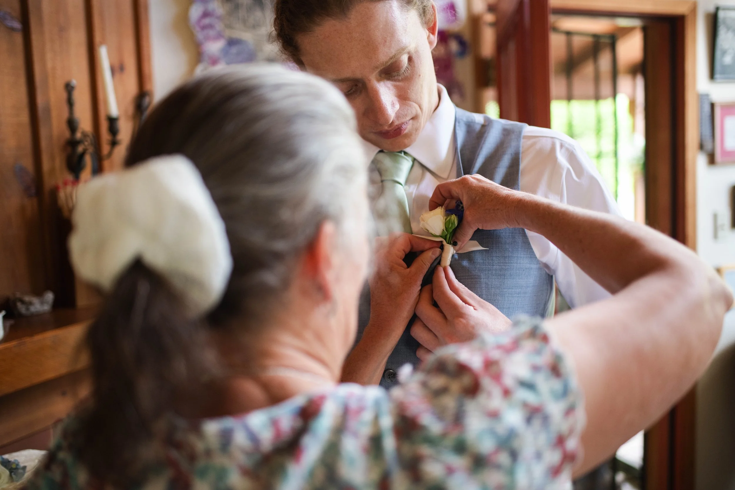 Mother pinning flowers on the groom before the wedding ceremony in Albuquerque New Mexico
