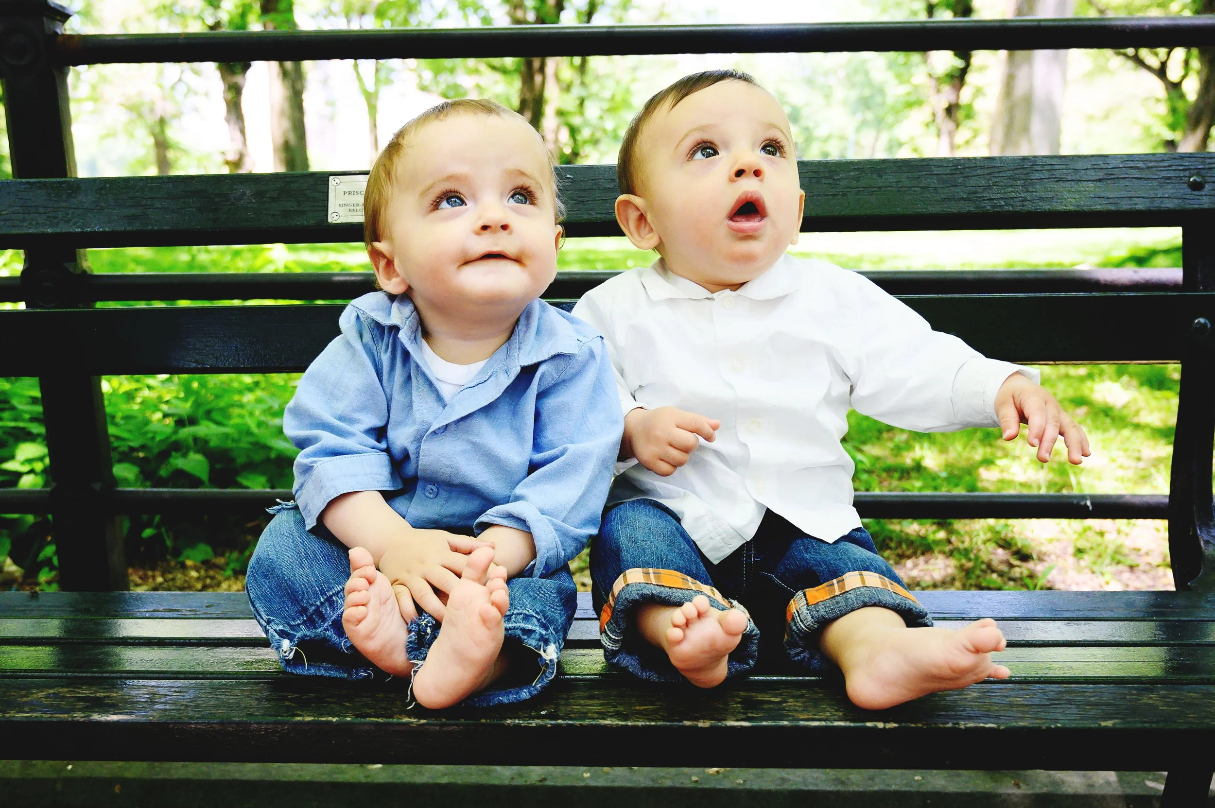 Twin babies smiling together on a bench during a family photo session in Central Park New York City