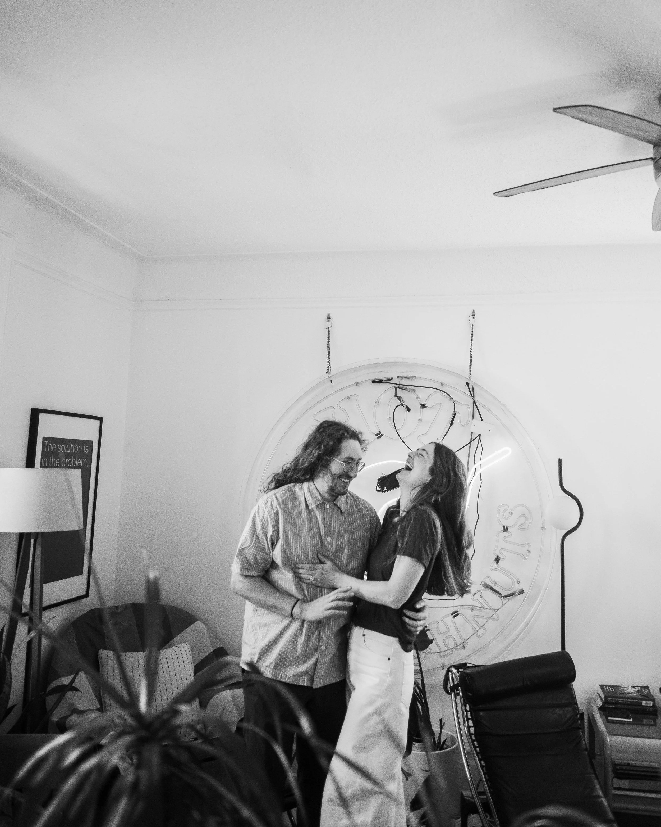 Candid tender moment of a couple embracing in their living room during an at-home Brooklyn engagement session
