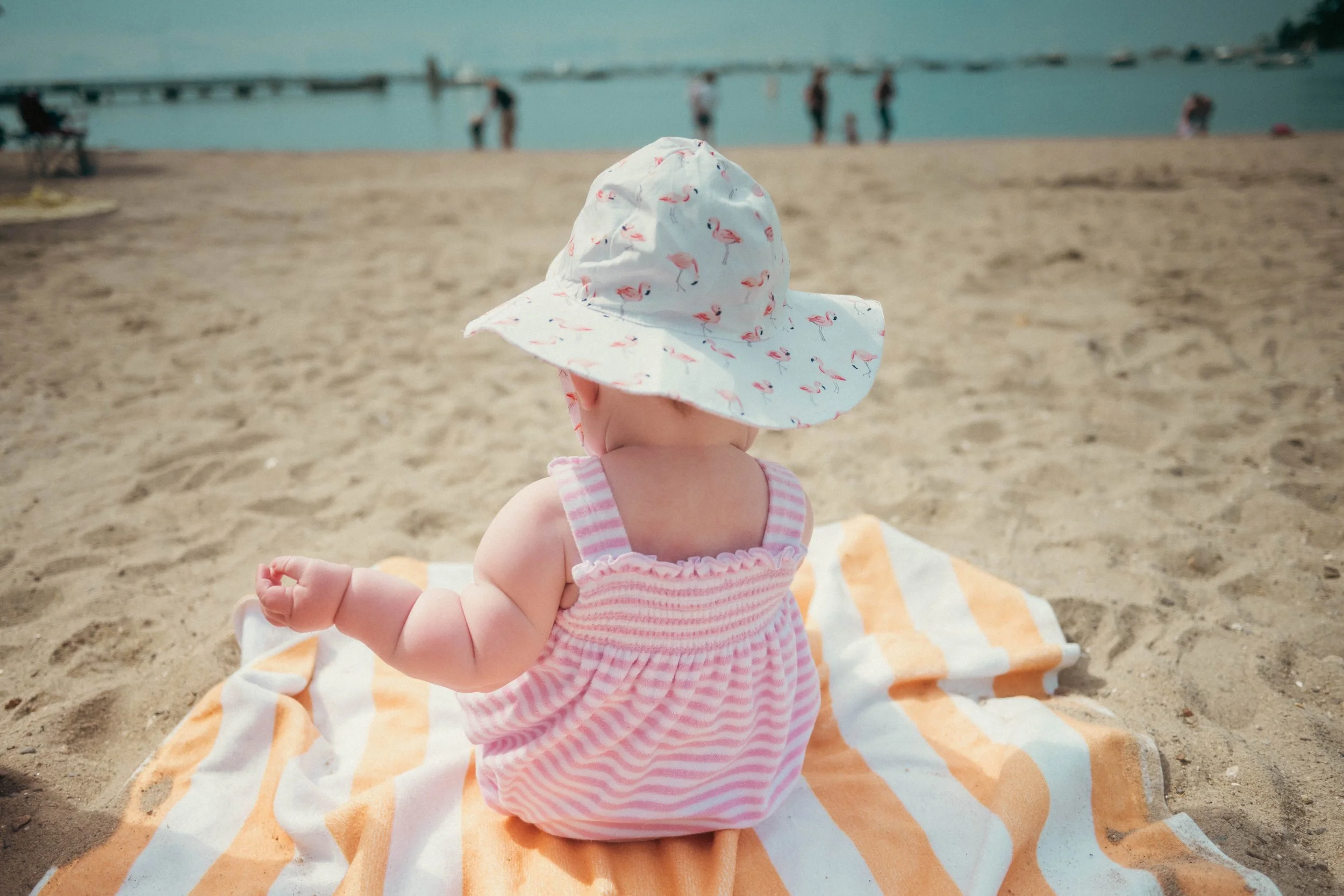 A baby playing in the sand on the beach in Fairfield County, Connecticut, captured by a local documentary family photographer.