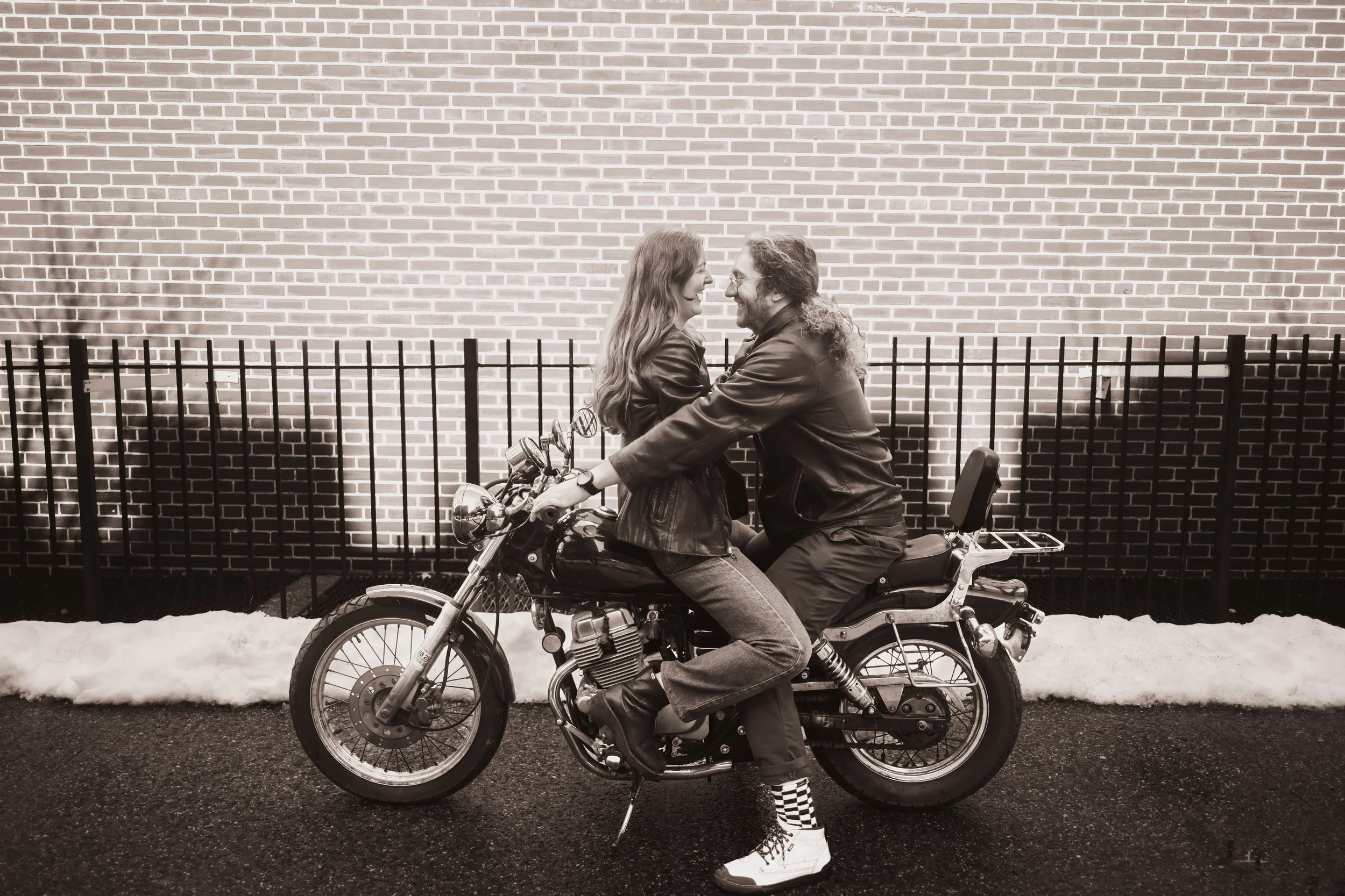 Couple posing on their motorcycle outside their Crown Heights Brooklyn apartment during an engagement session