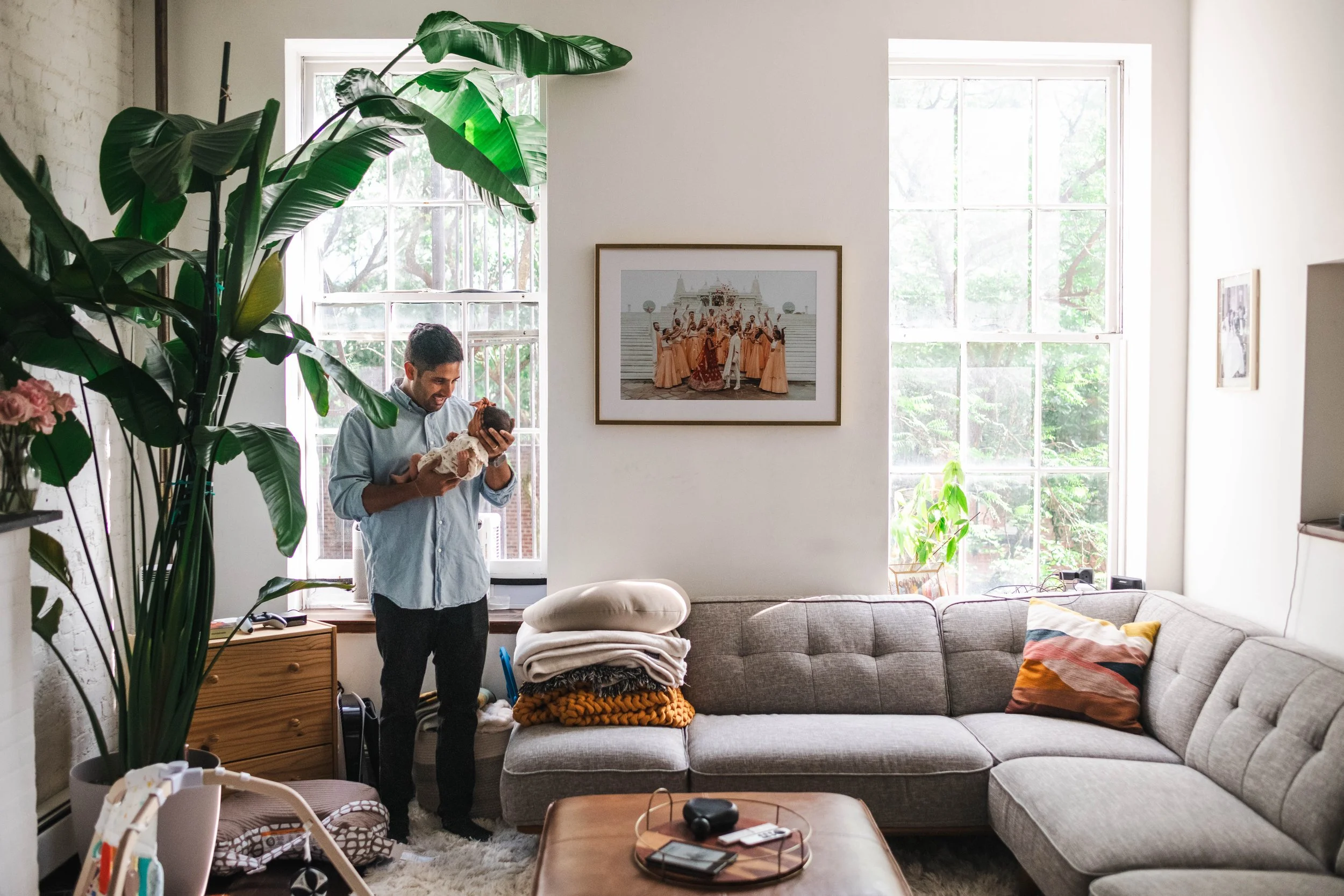 father holds newborn in apartment during photoshoot
