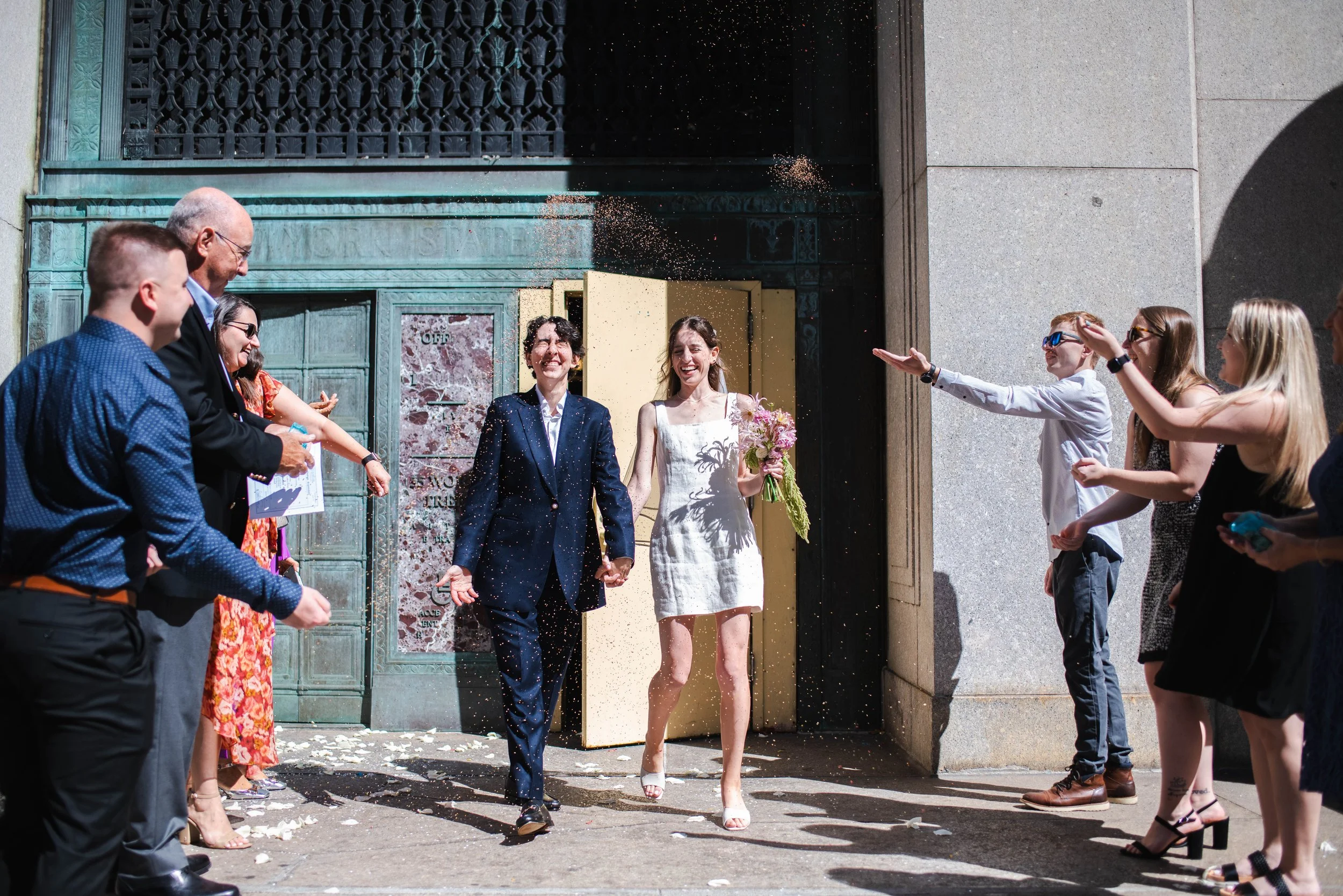 Queer couple exiting the NYC courthouse after their wedding ceremony