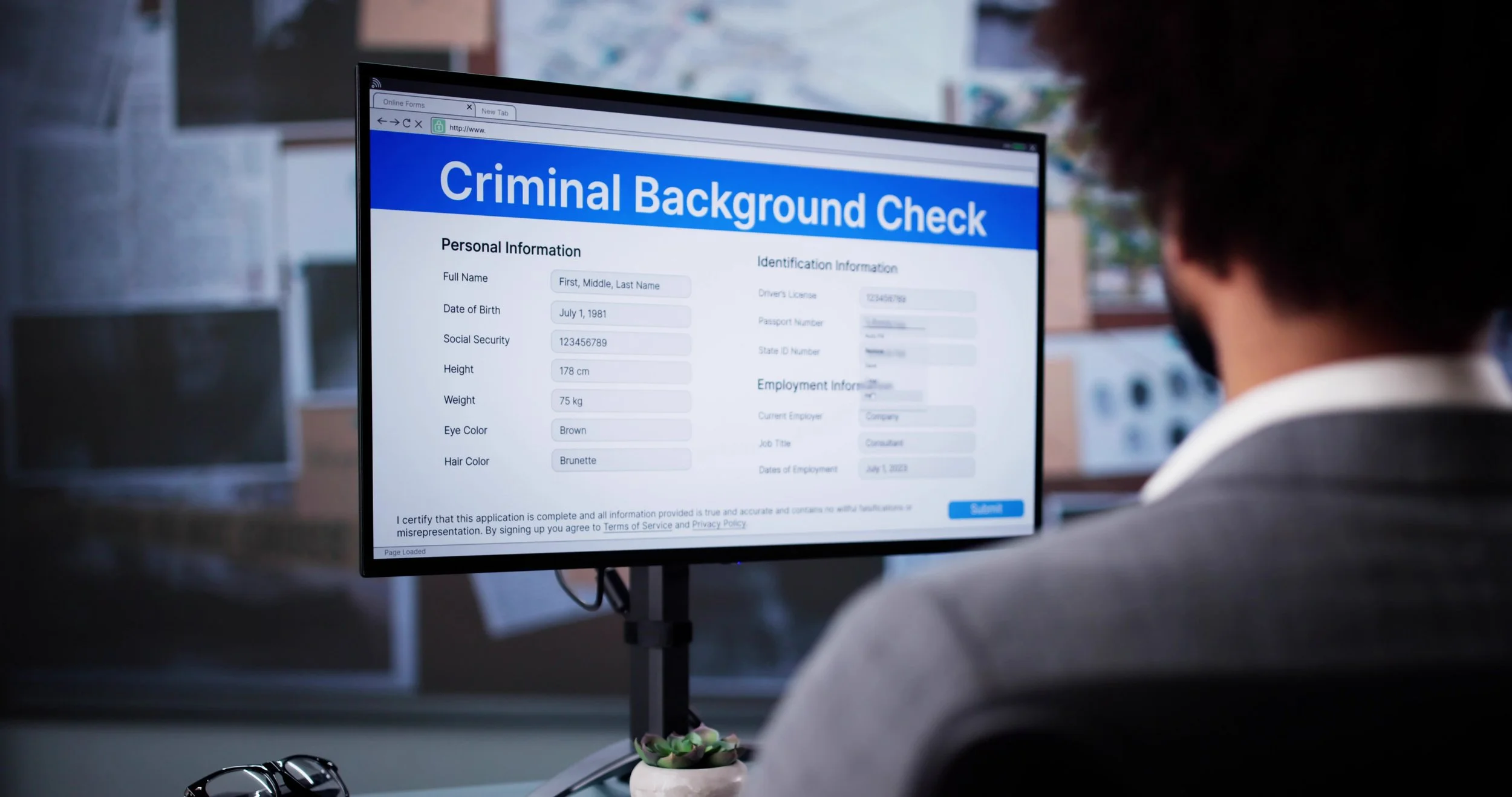 Person sitting at a desk with a computer monitor displaying a
