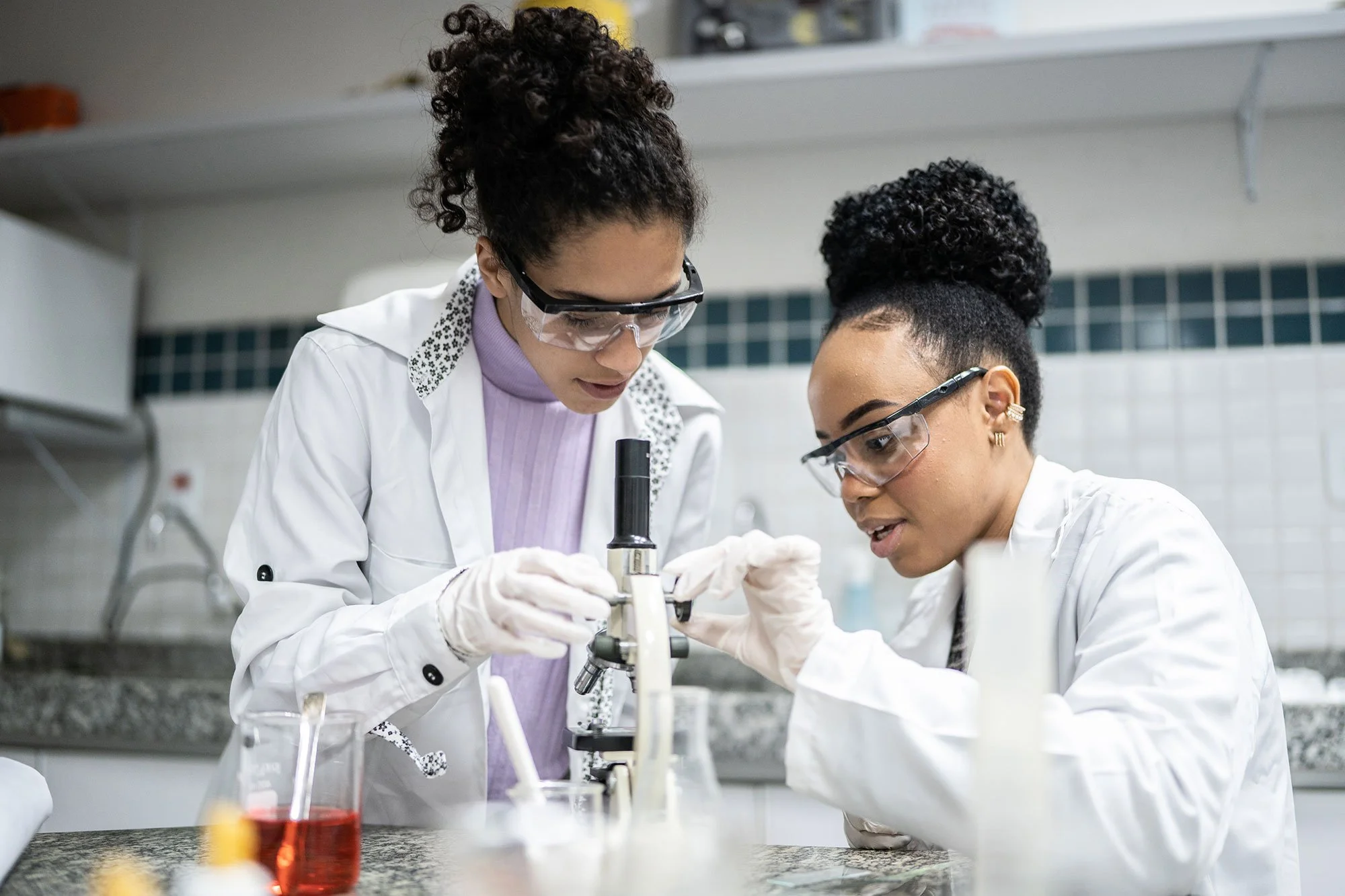 lab workers looking through microscope