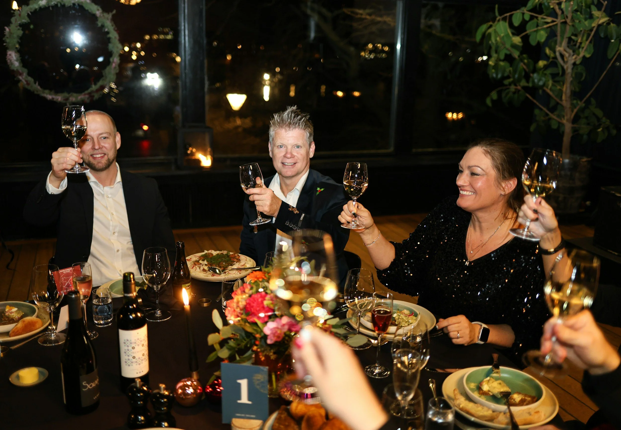 Women and well-dressed men sharing a group dinner during a cultural trip.