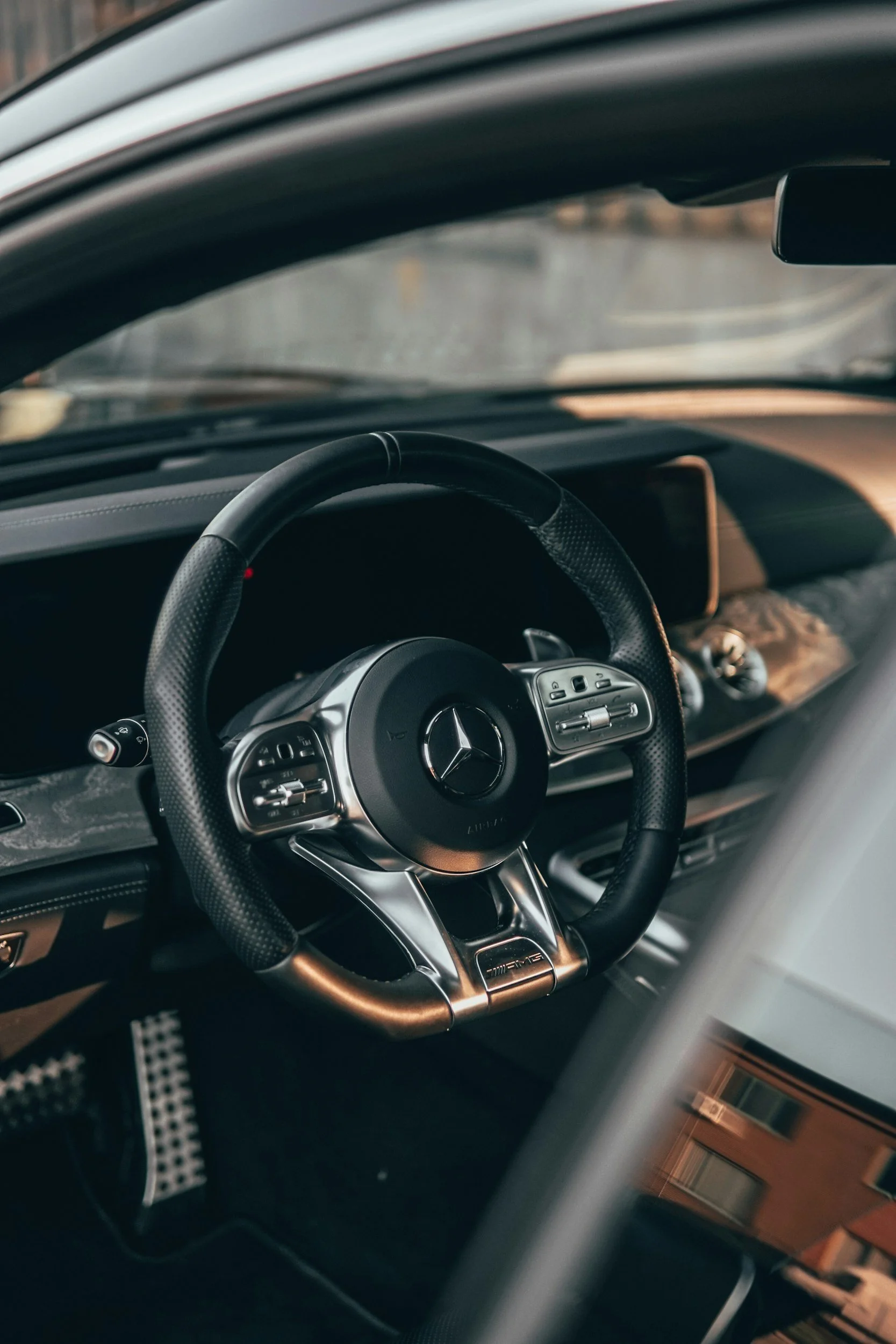 Interior of a luxury Mercedes-Benz vehicle, focusing on the steering wheel and dashboard.