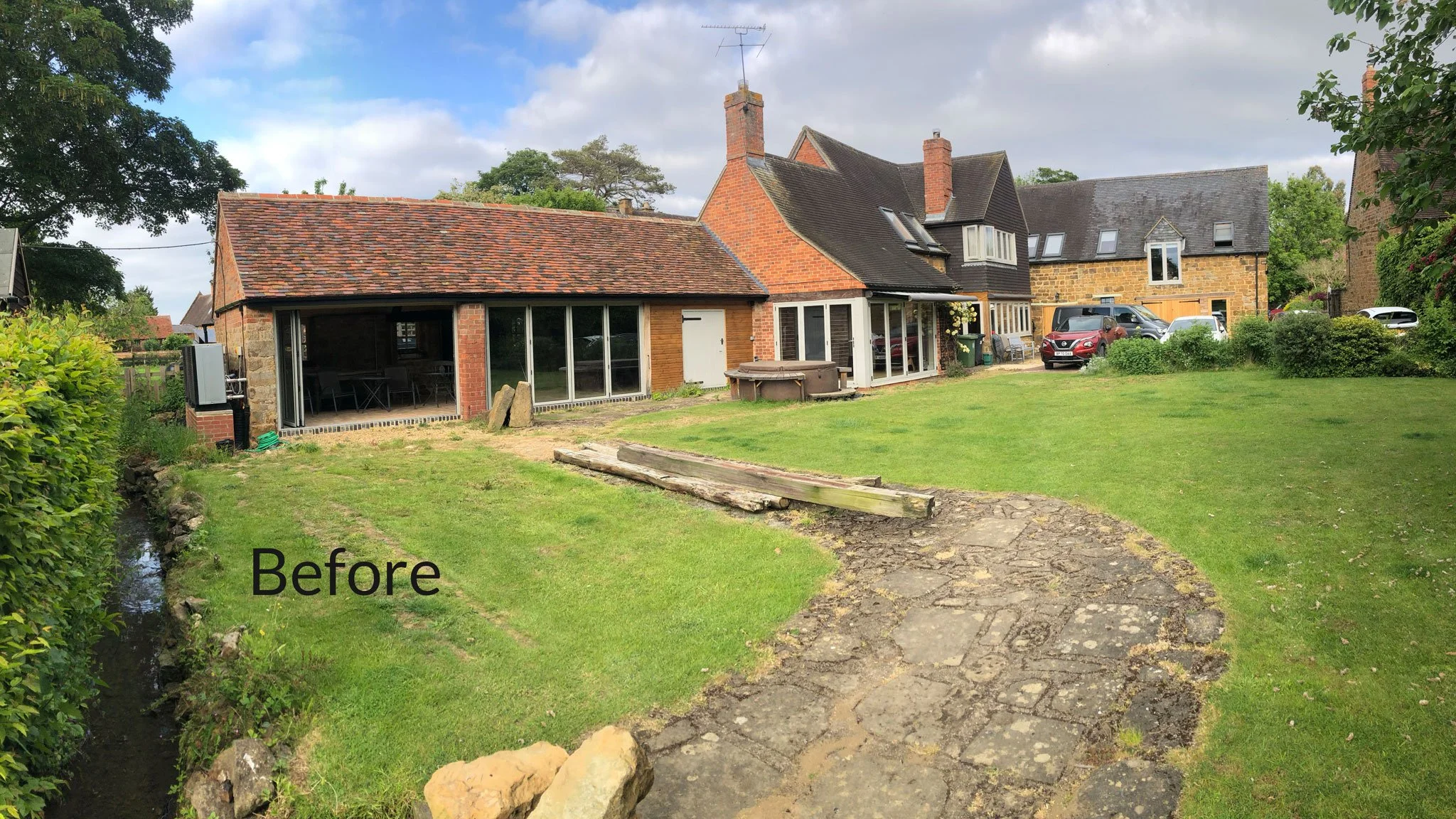 Before the redesign, showing the courtyard and converted barns prior to the new planting, walls and flood-resilient garden.