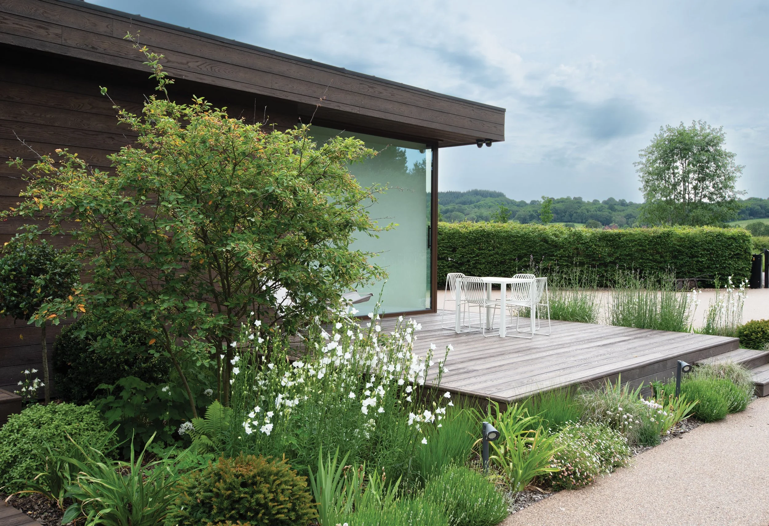 Long-flowering perennial planting beside the terrace, with open views maintained towards the surrounding countryside.
