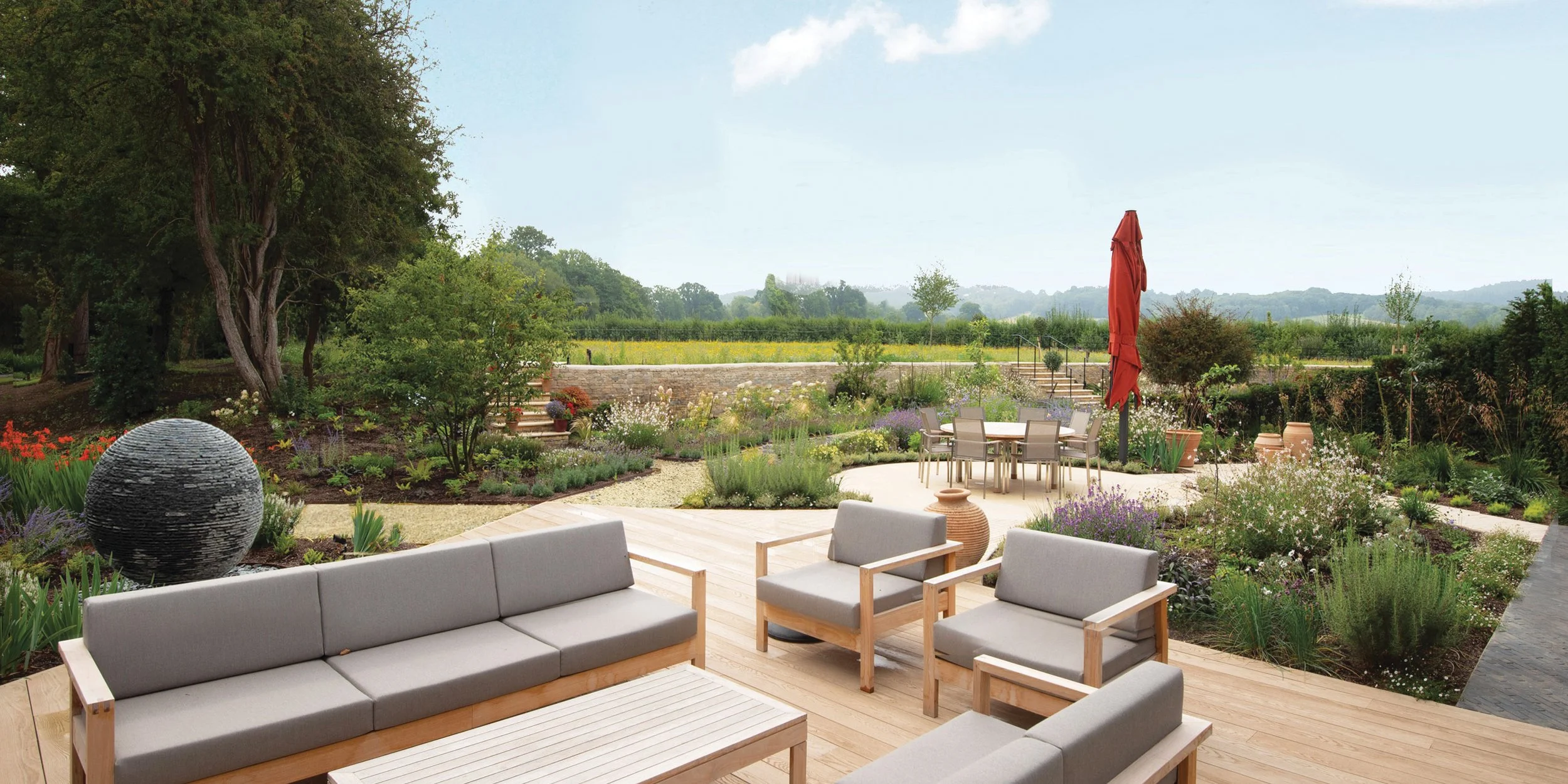 Modern garden design in Surrey with seating area, lawn and planting