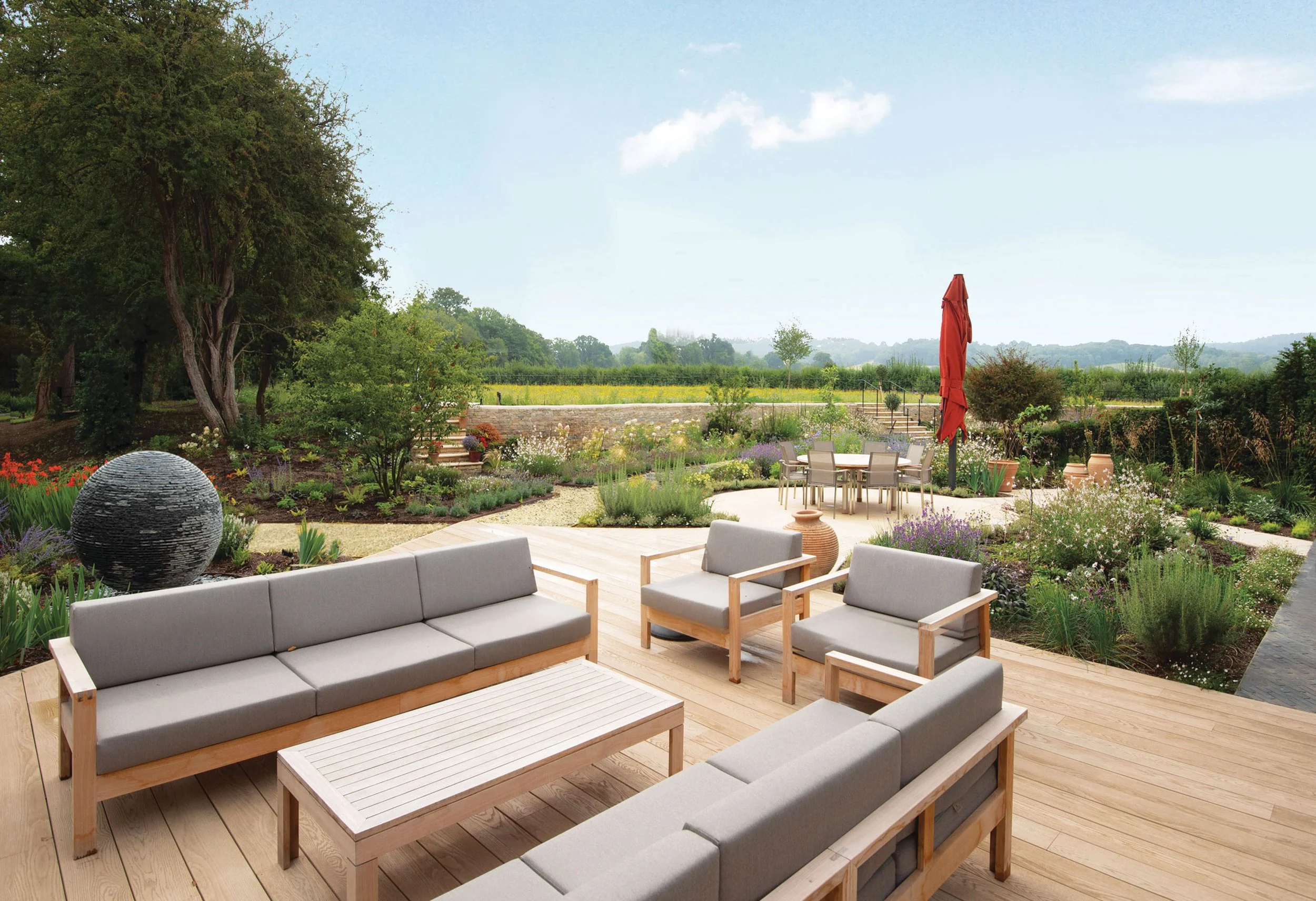 Decking Millboard terrace with views to AONB Hills, with contemporary outdoor furniture and naturalistic planting beyond.