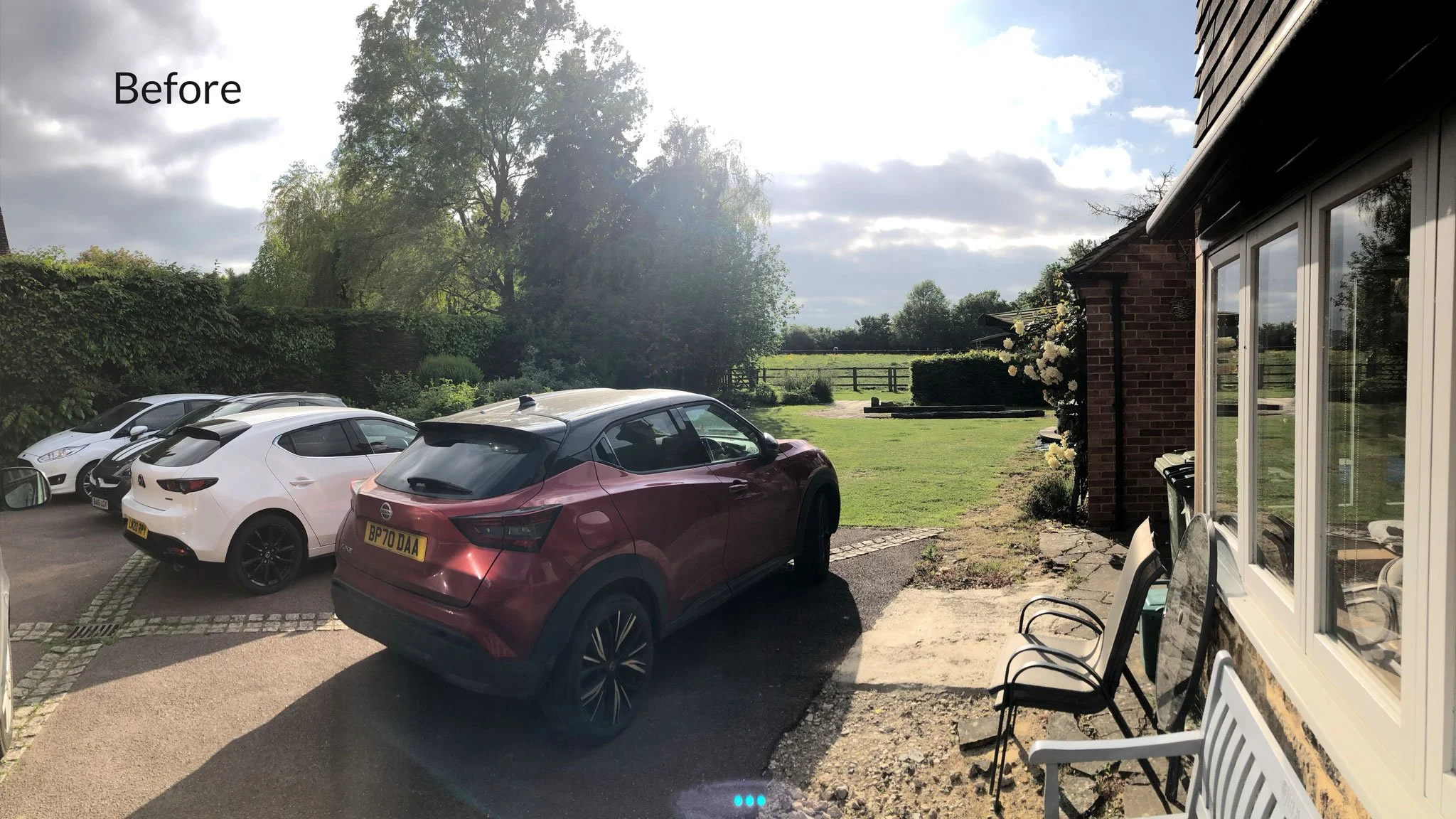 Before the garden was created, showing the existing parking area and open landscape beyond the property.
