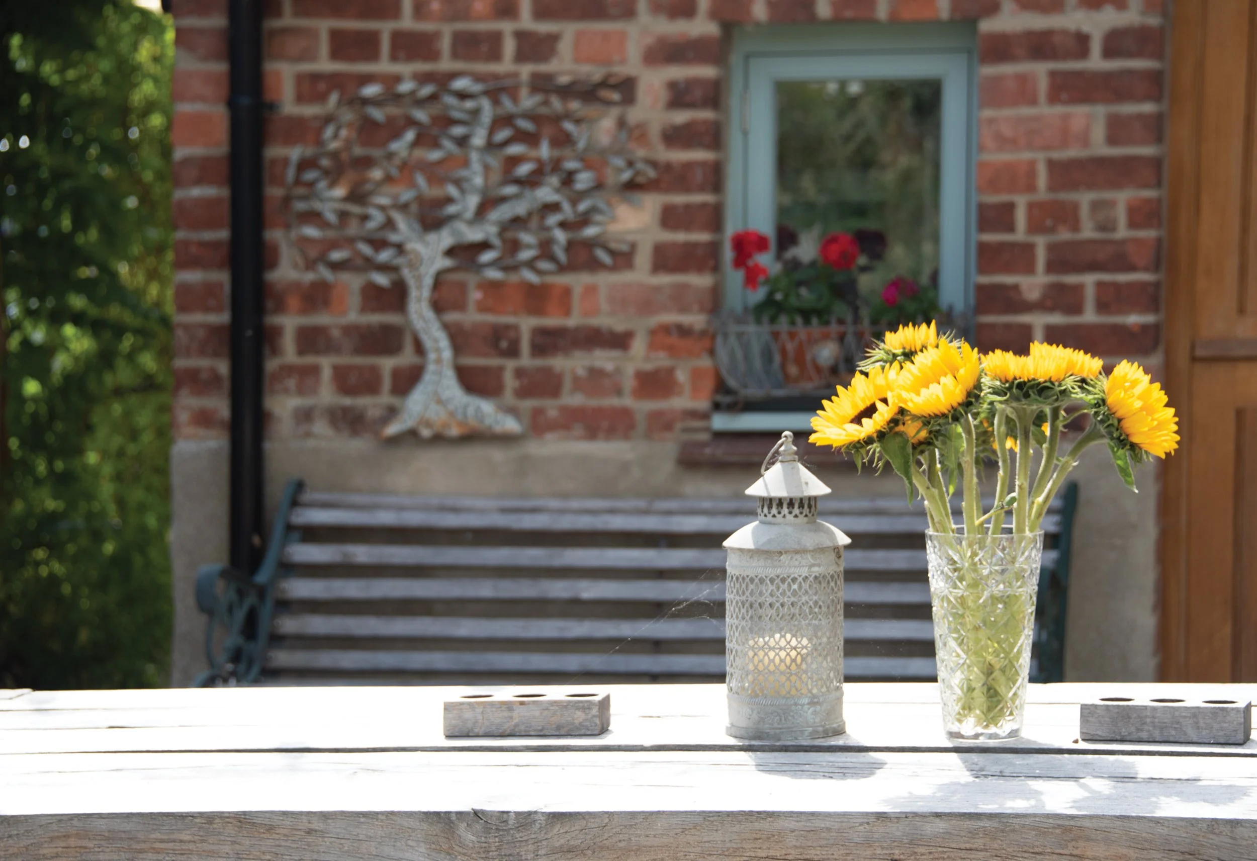 Arts and Crafts-inspired wall decoration, sculpture and cut flowers bringing the owner’s character into the courtyard garden.