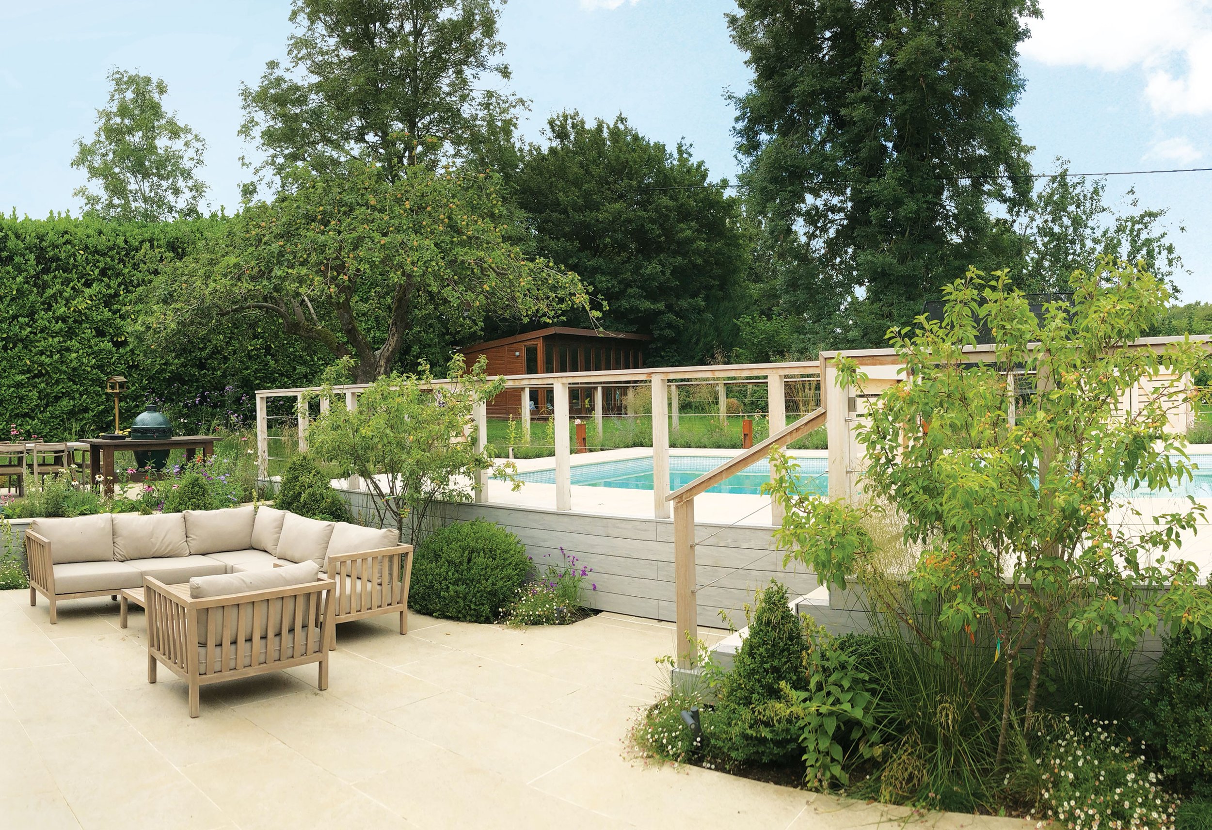 Family lounging terrace with layered planting creating a soft transition towards the enclosed swimming pool.