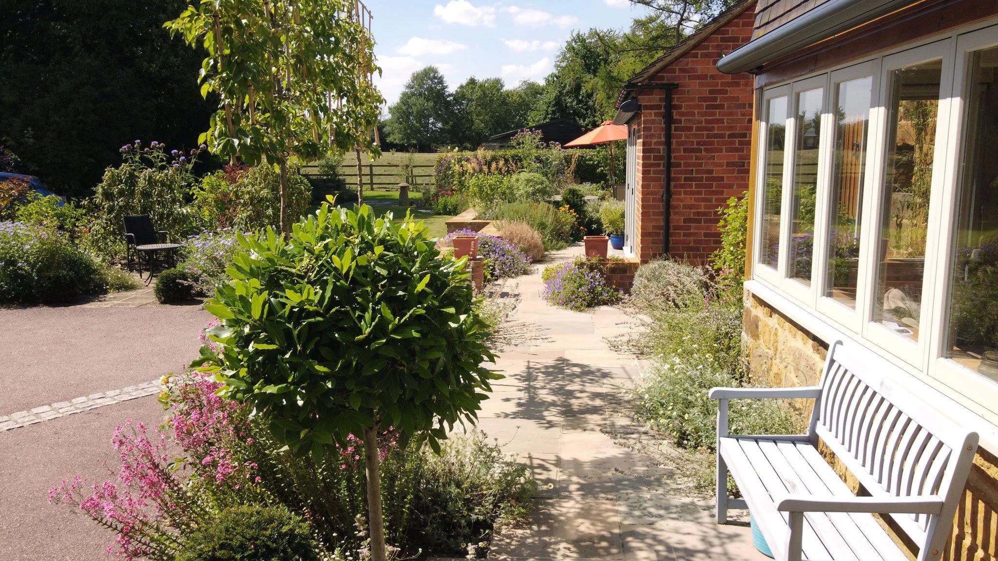 Path through richly planted perennial borders connecting the different spaces around the courtyard.