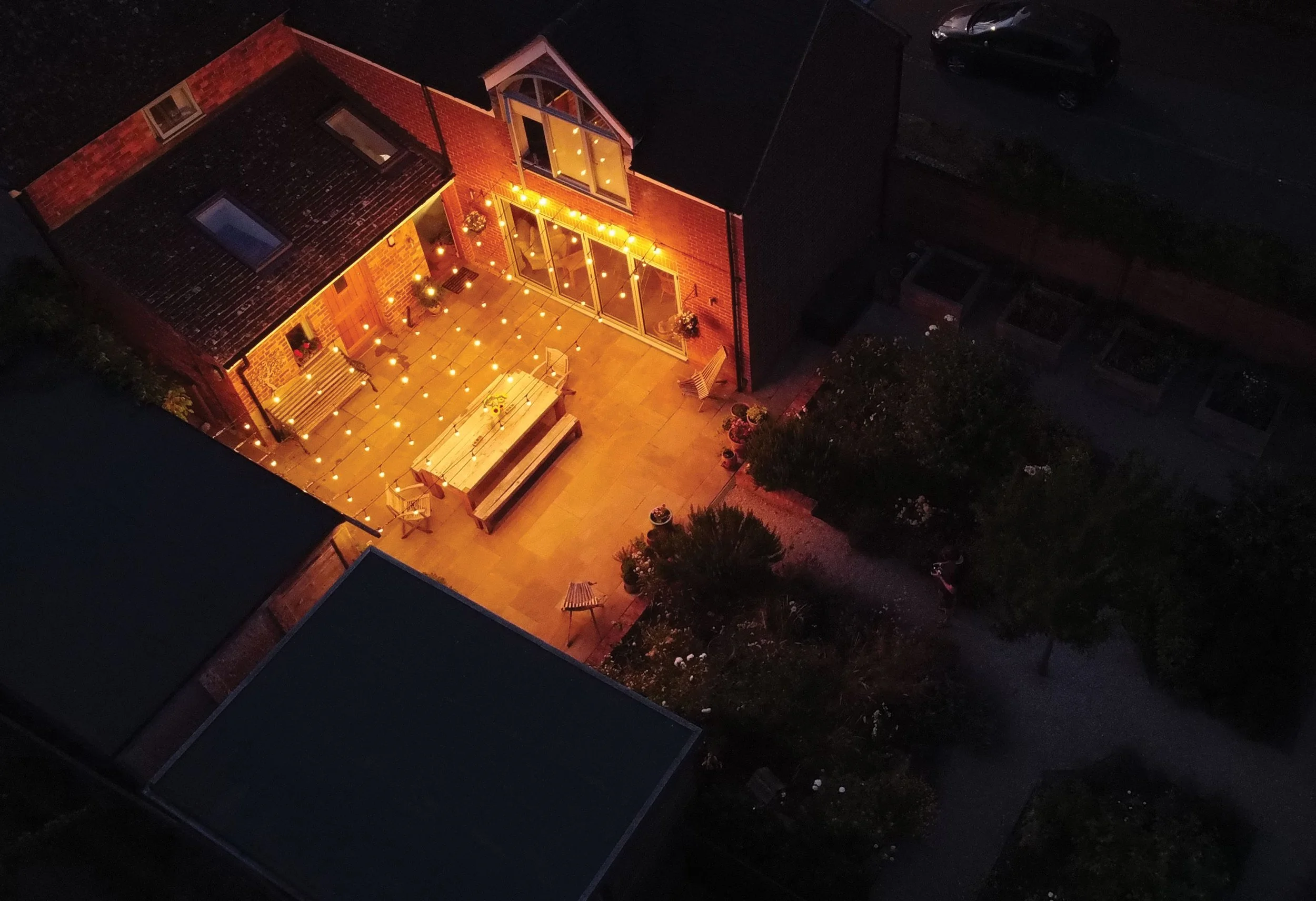 Evening view of the courtyard, where lighting transforms the formal dining space into an intimate outdoor room.