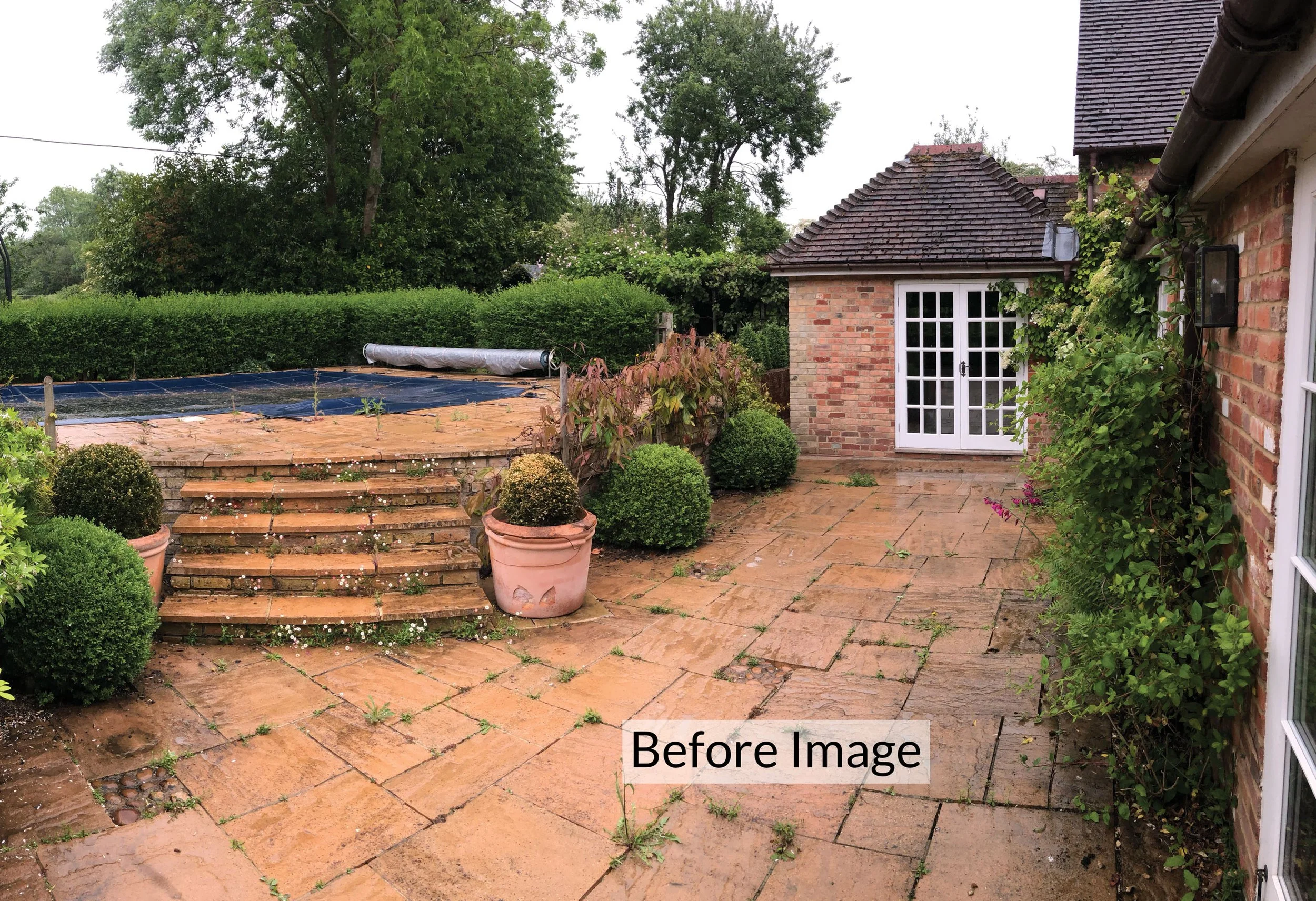 Before the redesign, showing the awkward existing swimming pool, brick terraces and steps beside the house.