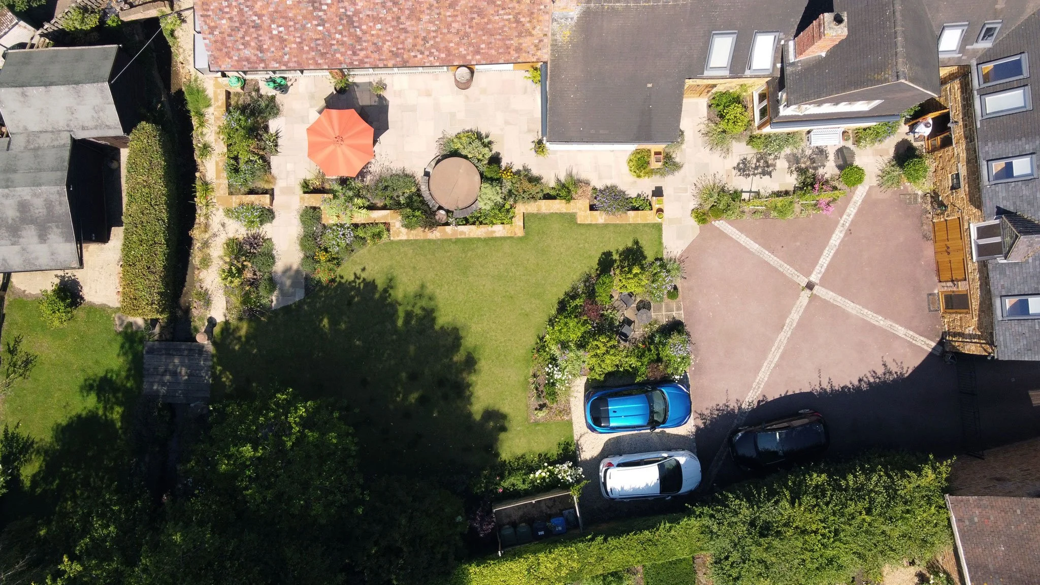 Aerial view of The Courtyard Garden in Fenny Compton, Warwickshire, showing the Grade II listed property, converted barns, courtyard and parking area.