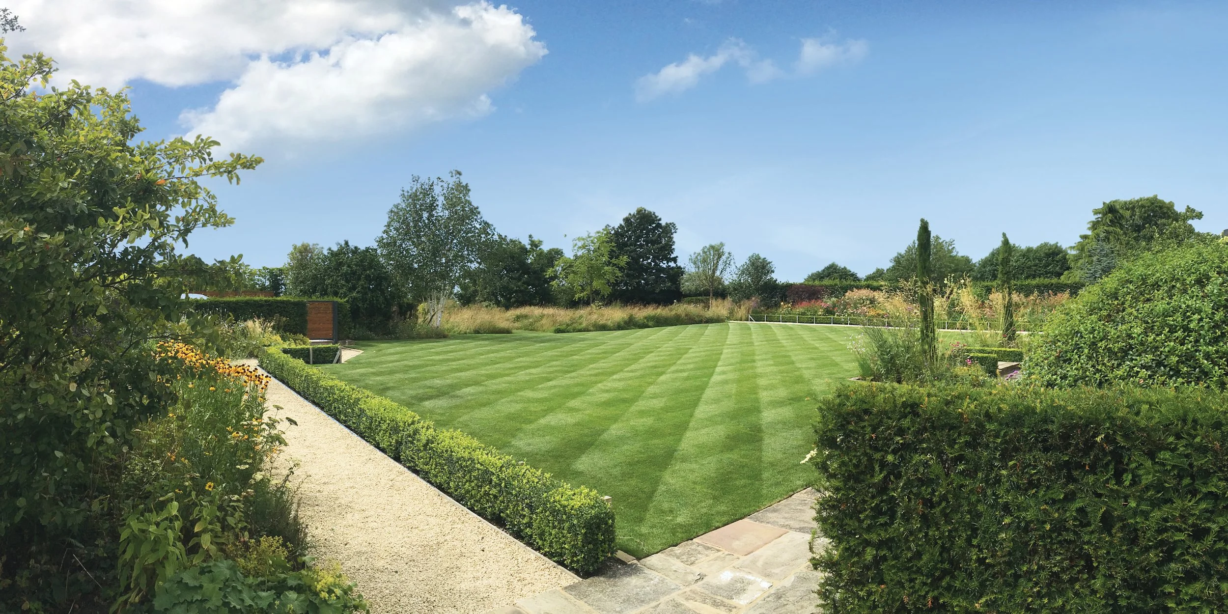 Traditional garden design in the Cotswolds with lawn, hedging and open views