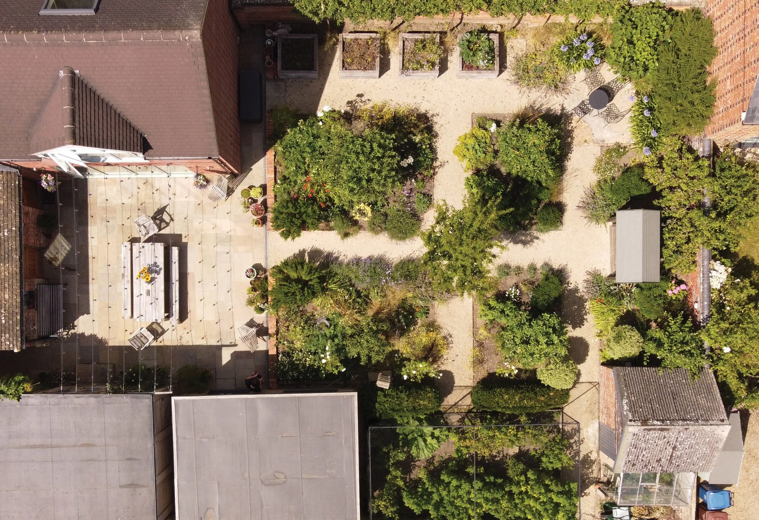 Wide view across the productive garden, with fruit trees and raised vegetable beds arranged to make full use of the available space.