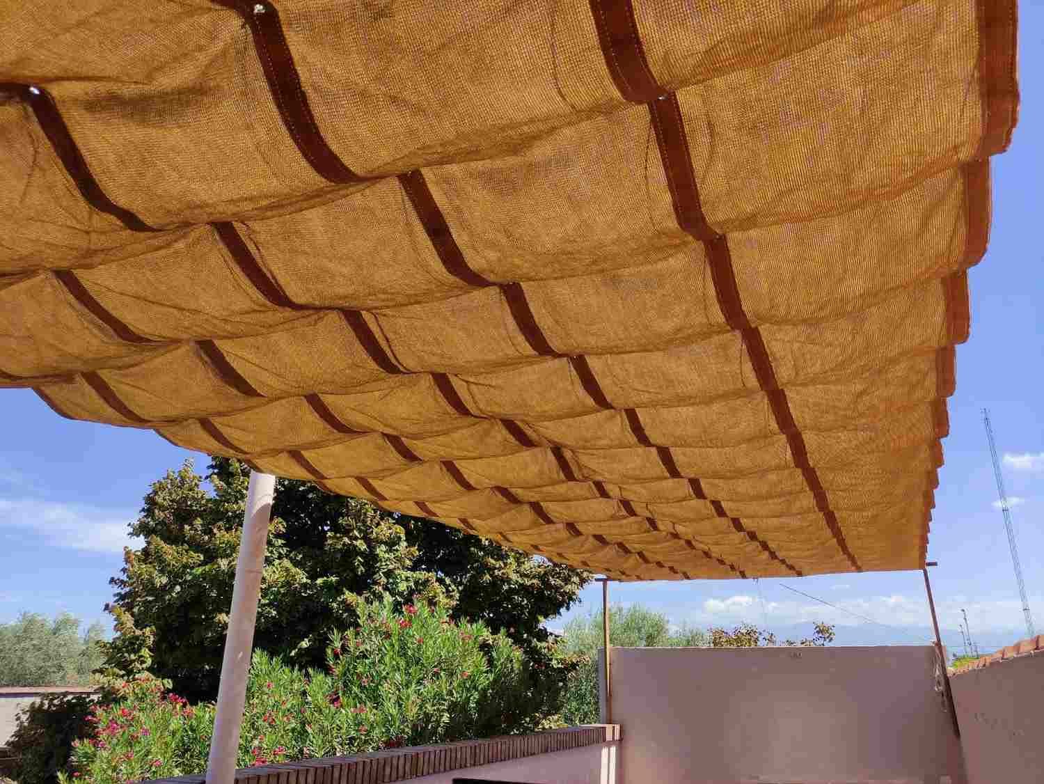 Toldo deslizable por rieles tensados, solución para sombra regulable en espacios exteriores.