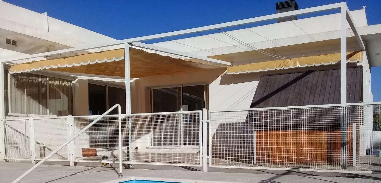 Toldo corredizo de PVC cristal para protección solar en terraza, con estructura metálica ligera.