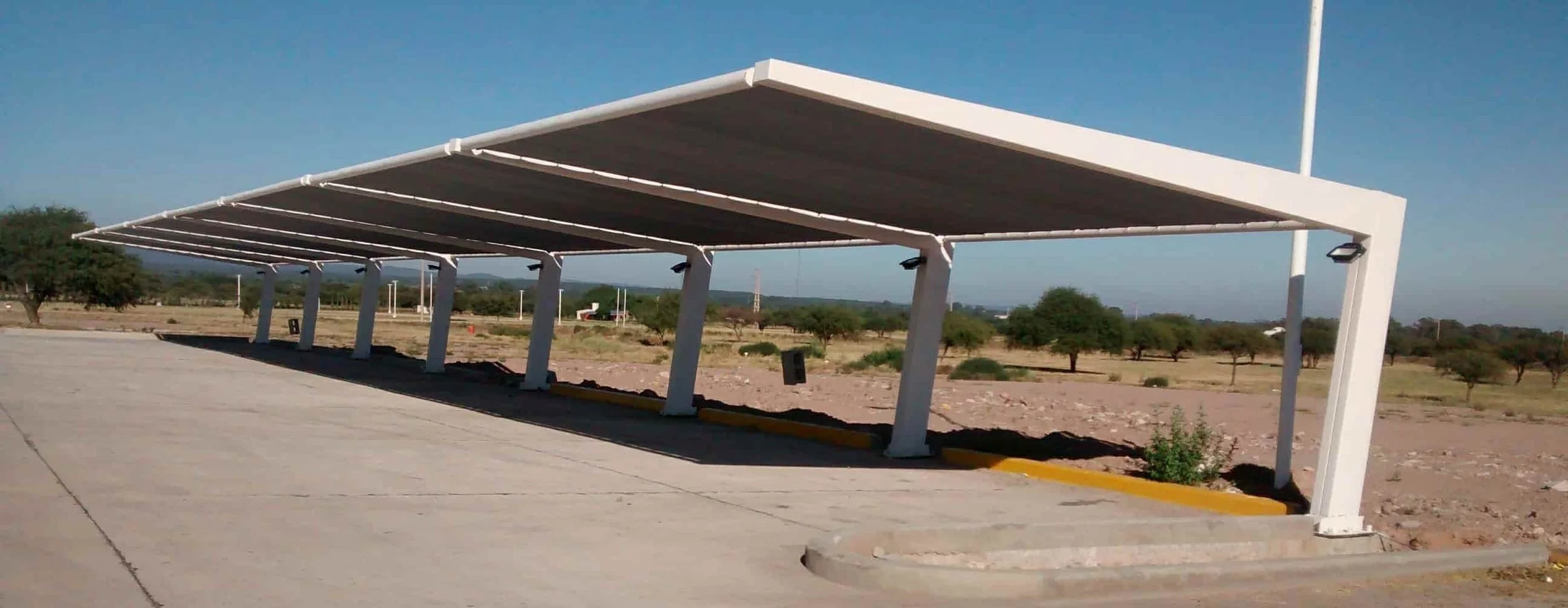 Cobertura de lona impermeable color gris instalada en estructura metálica para vehículos.