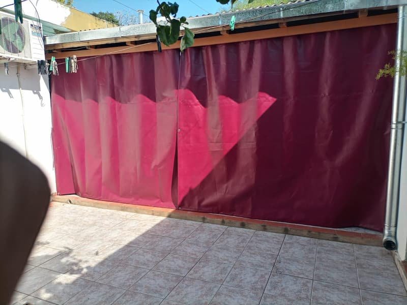 Cortina corrediza de lona para exterior con barral metálico, ideal para galerías, quinchos y patios – protección solar y contra lluvia.