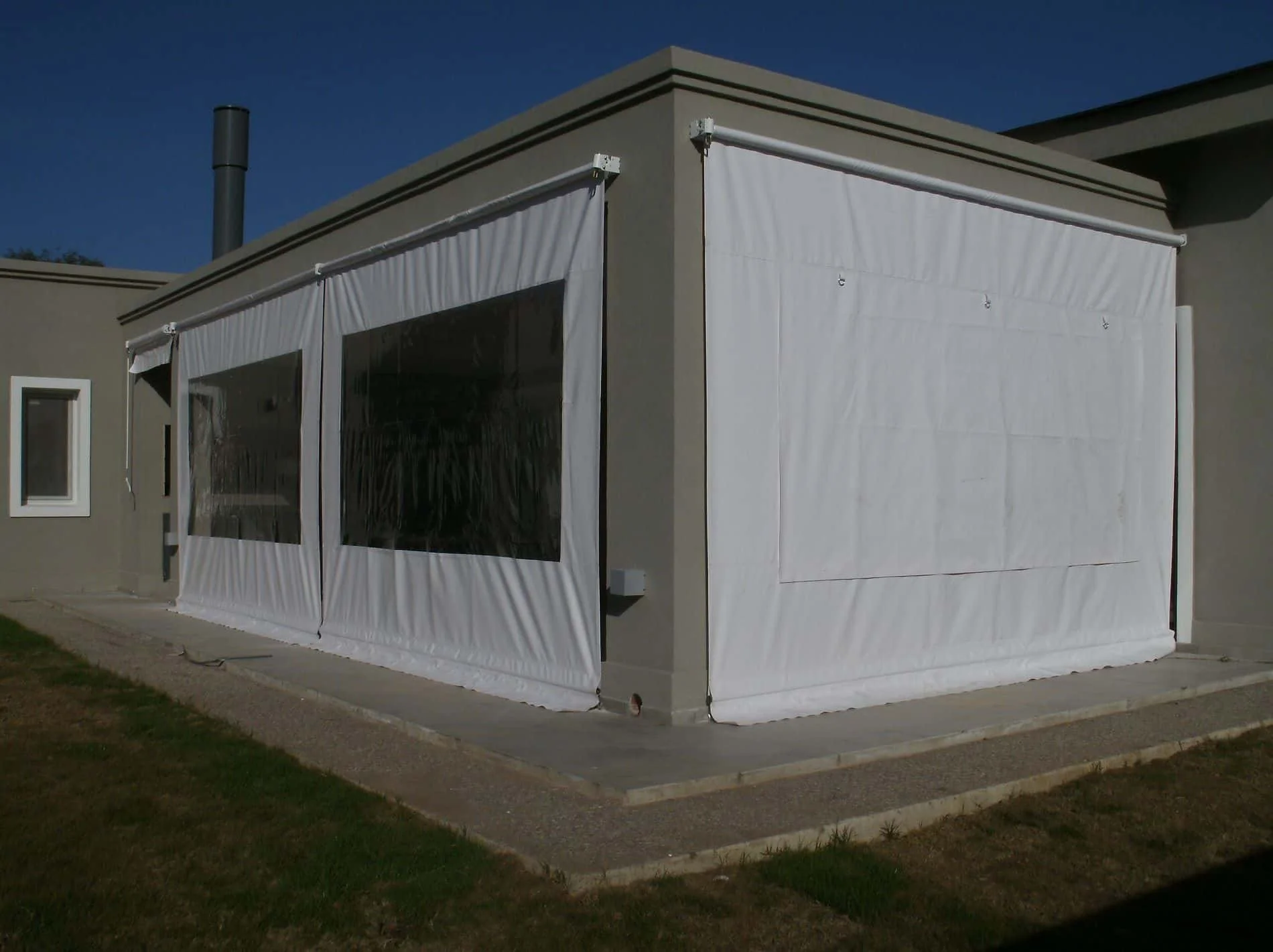 Vista frontal de cerramiento de lona para galería, con ventana transparente de PVC cristal.

