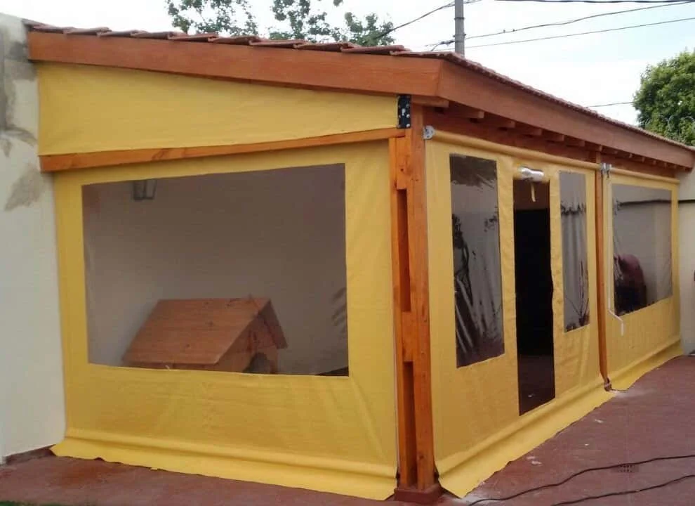 Cerramiento con cortinas levadizas de lona PVC en galería, protección contra sol y viento.

