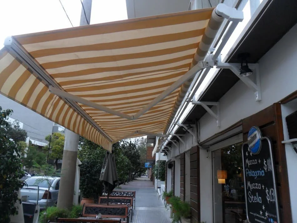 Toldo brazo invisible con lona sauleda. Soporte con refuerzo
