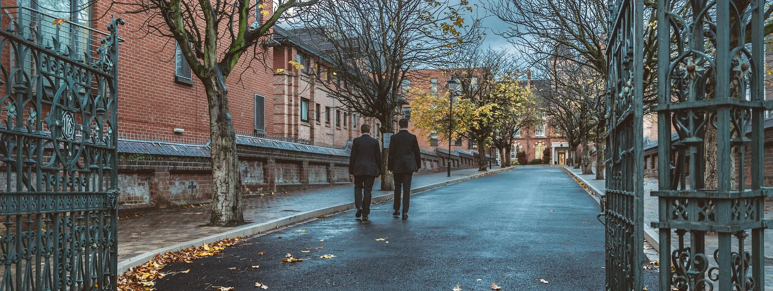 An image of the College Avenue at St. Malachy's College, Belfast with two students walking up with their backs turned.