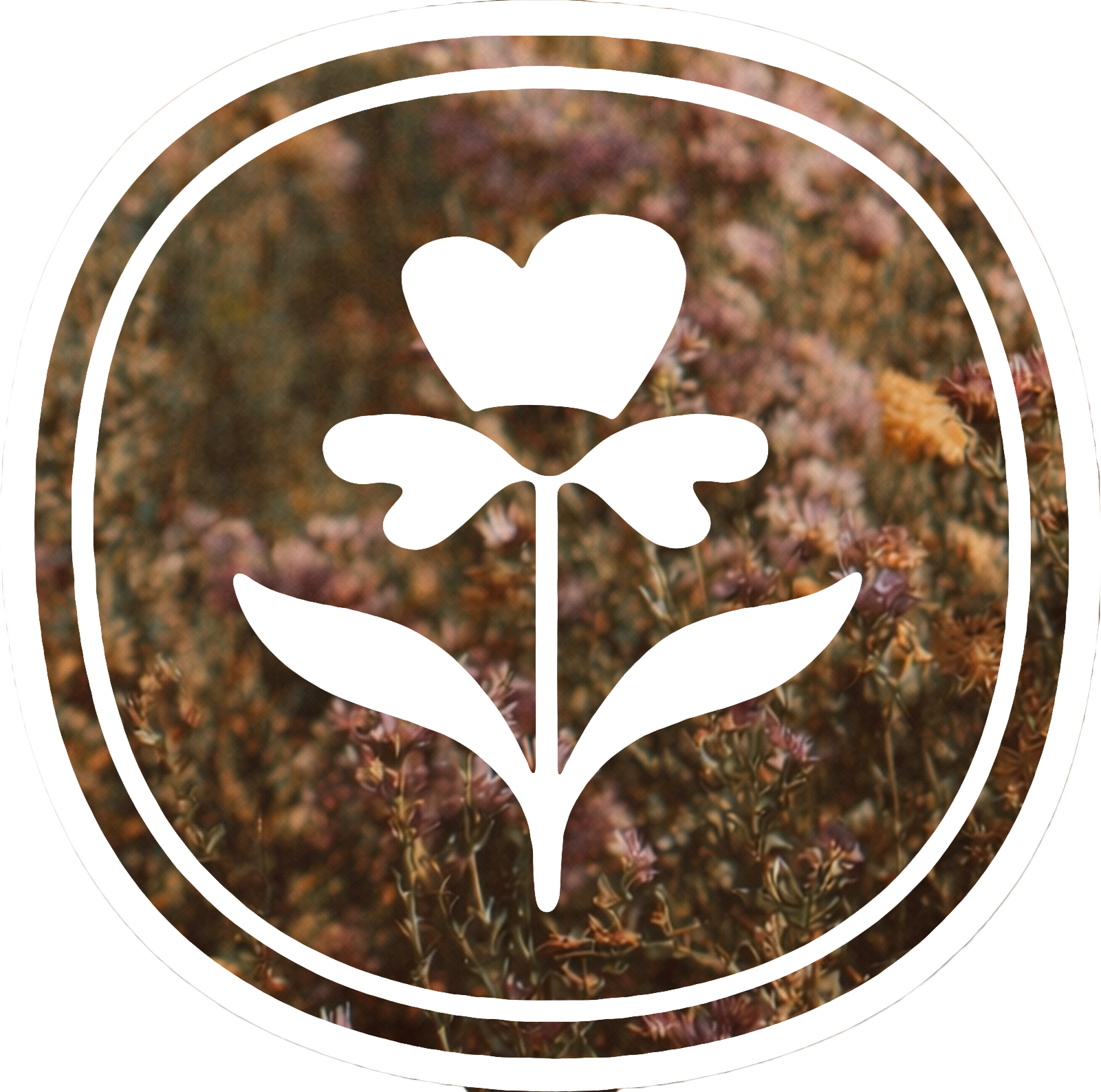 A white outline of a flower with a heart-shaped top, two leaves, and a stem, set against a blurred background of brown and orange plants.