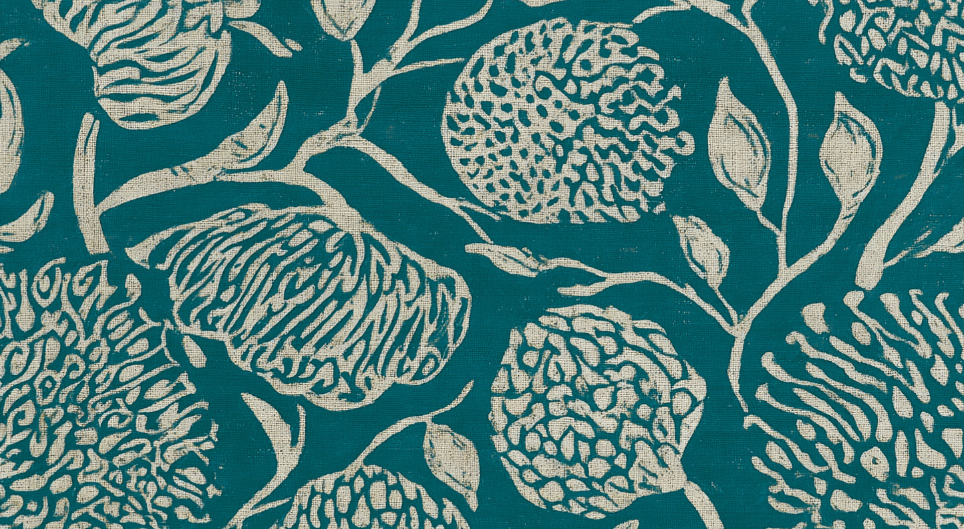 Close-up of a teal fabric with a white floral pattern, featuring outlined pomegranates, leaves, and branches.